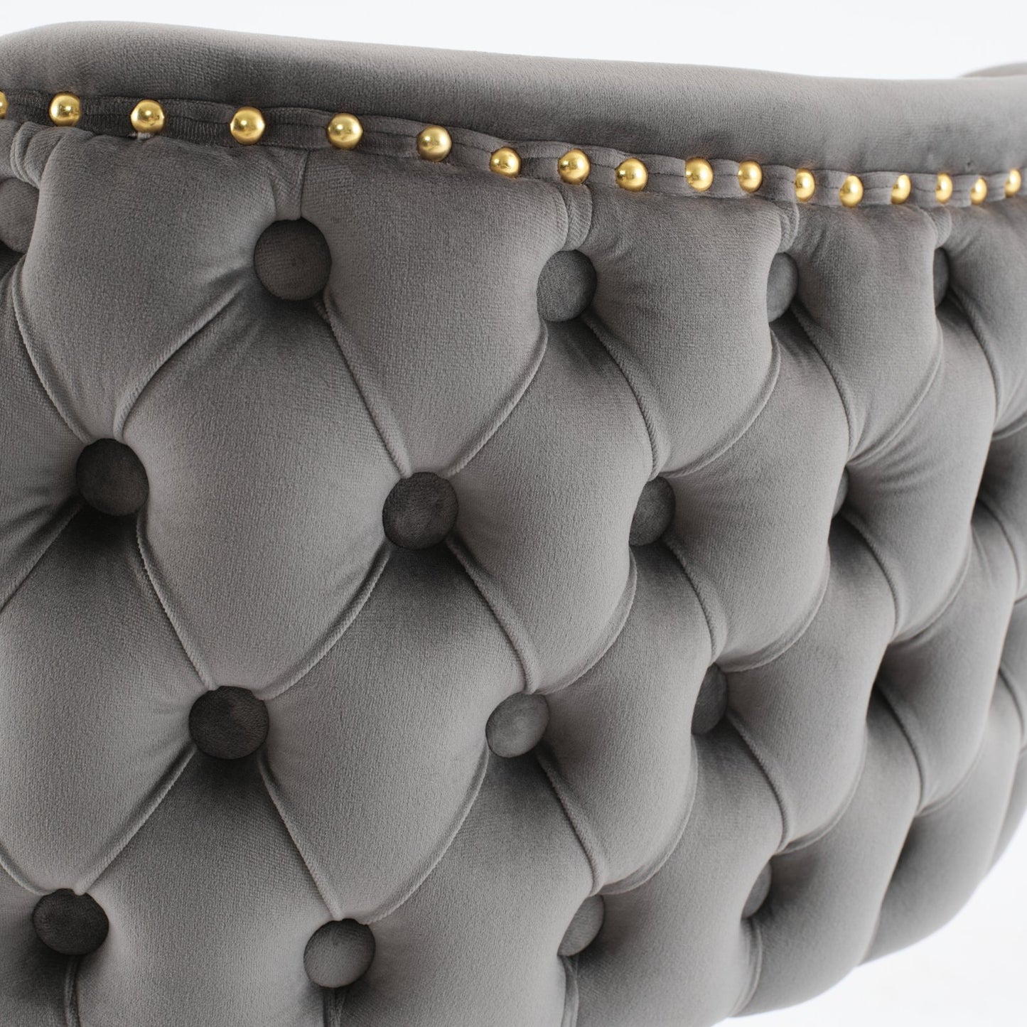 Grey velvet tufted armchair detail with brass nailhead trim