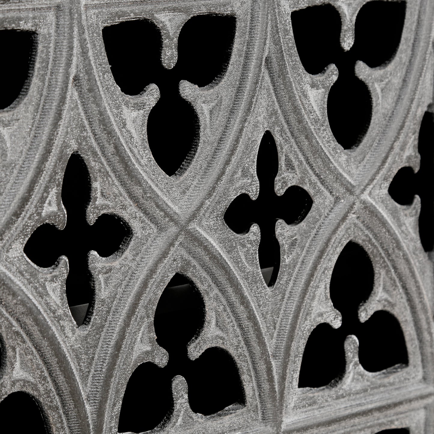 Textured grey ornate decorative screen with gothic tracery