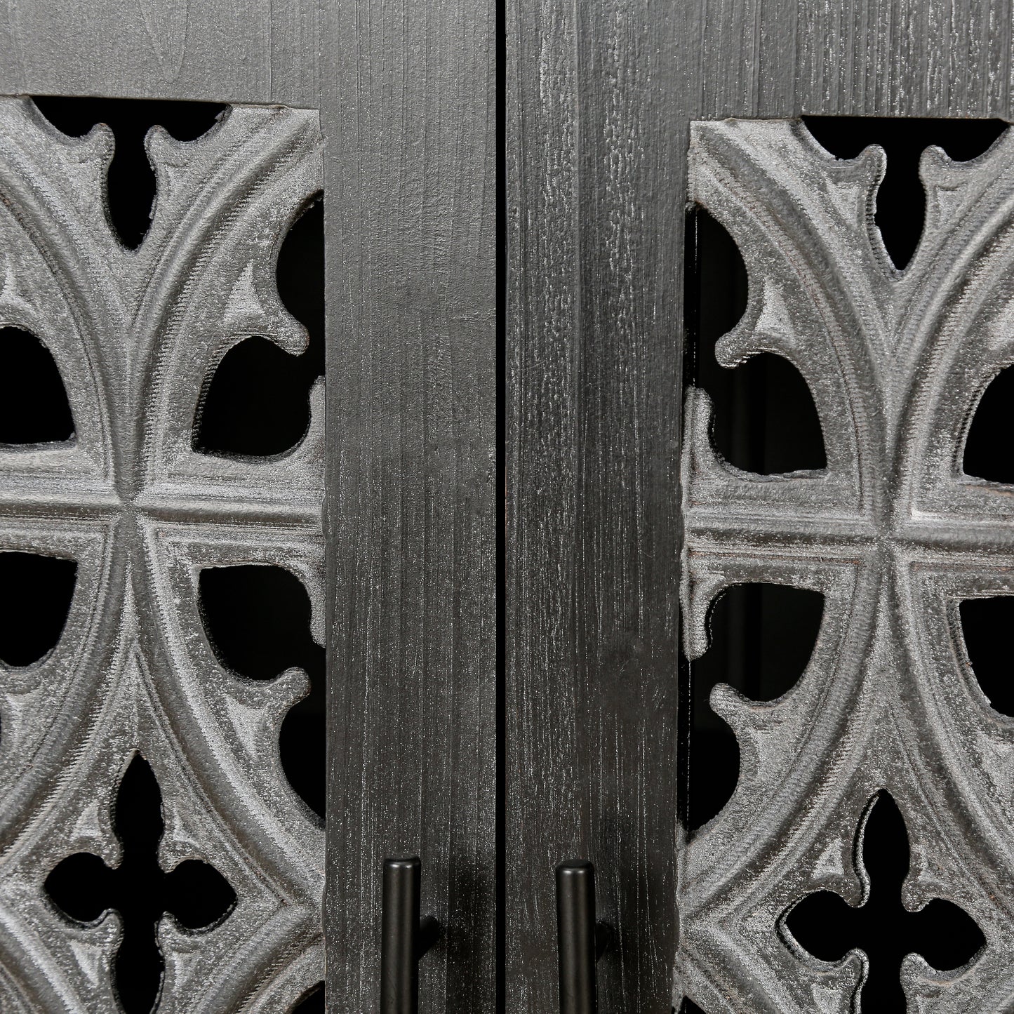 Close up of dark grey wooden cabinet doors with ornate gothicstyle metal grilles
