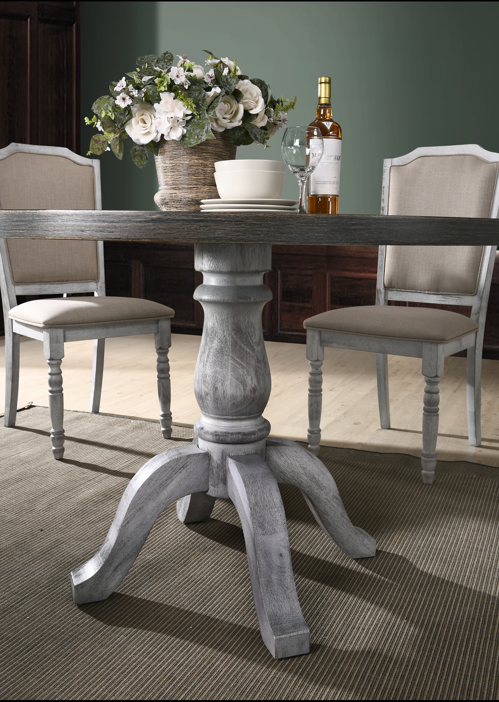 Rustic gray pedestal dining table with upholstered chairs