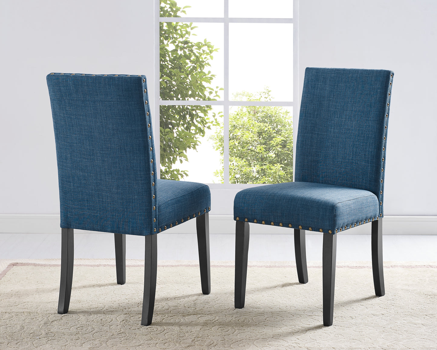 Blue upholstered dining chair with brass nailhead trim and dark wood legs