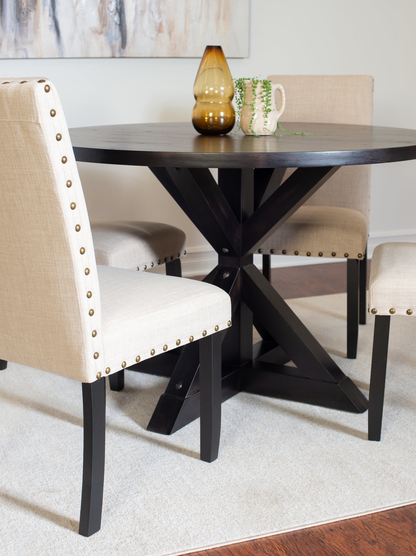 Dark wood round dining table with linen upholstered chairs