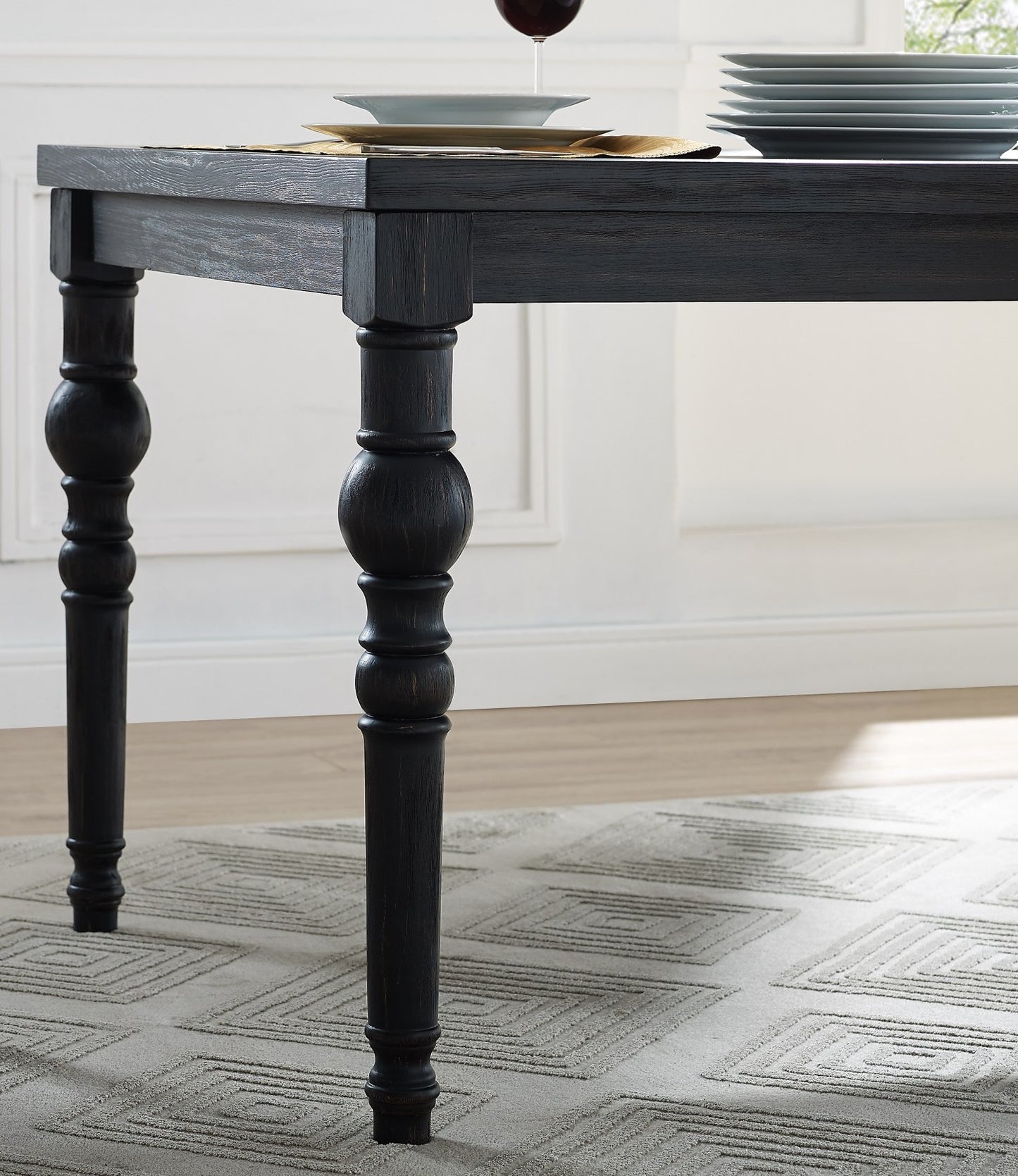 Closeup of black wood dining table legs with turned details