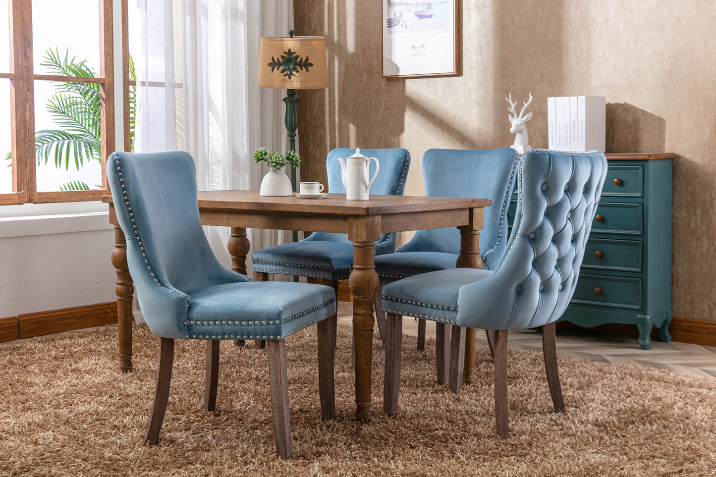 Tufted blue velvet dining chair with silver nailhead trim and dark wood legs