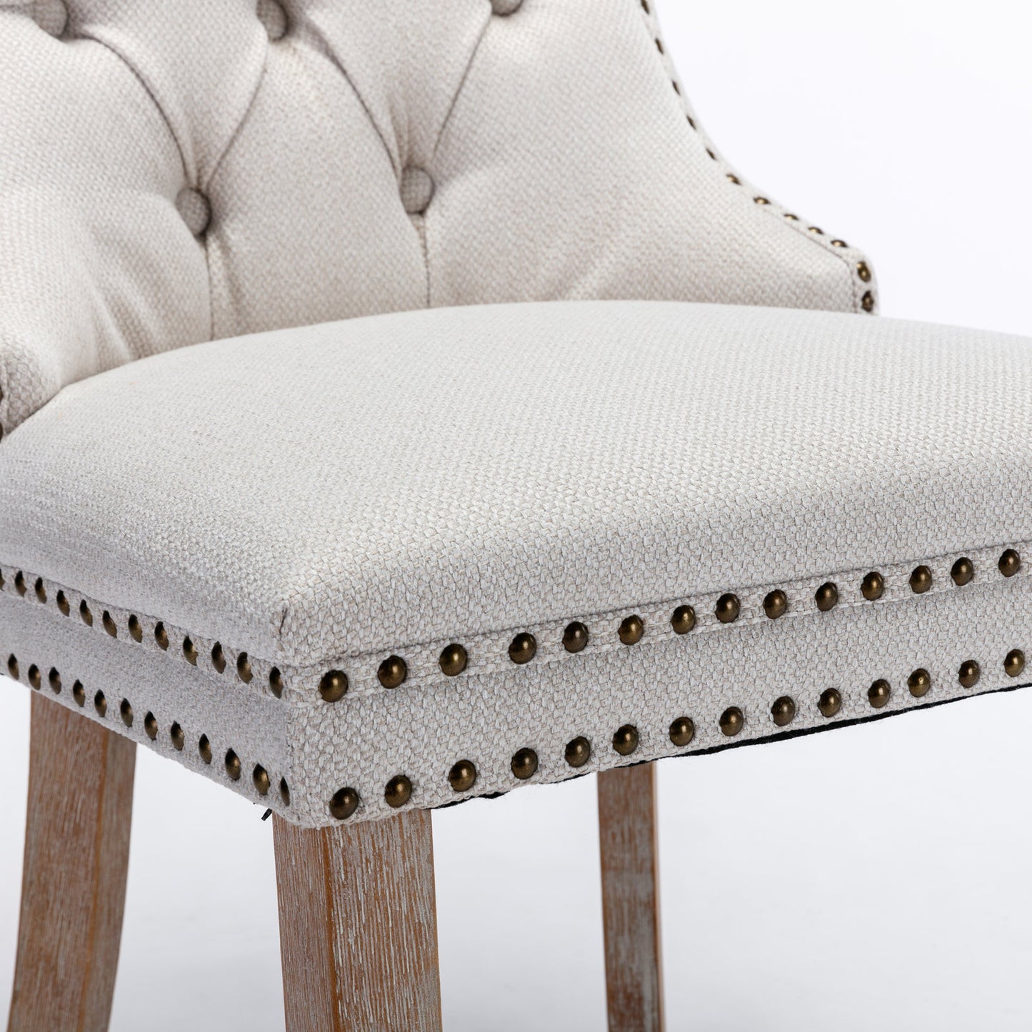 Tufted linen accent chair in neutral beige with antique brass nailhead trim