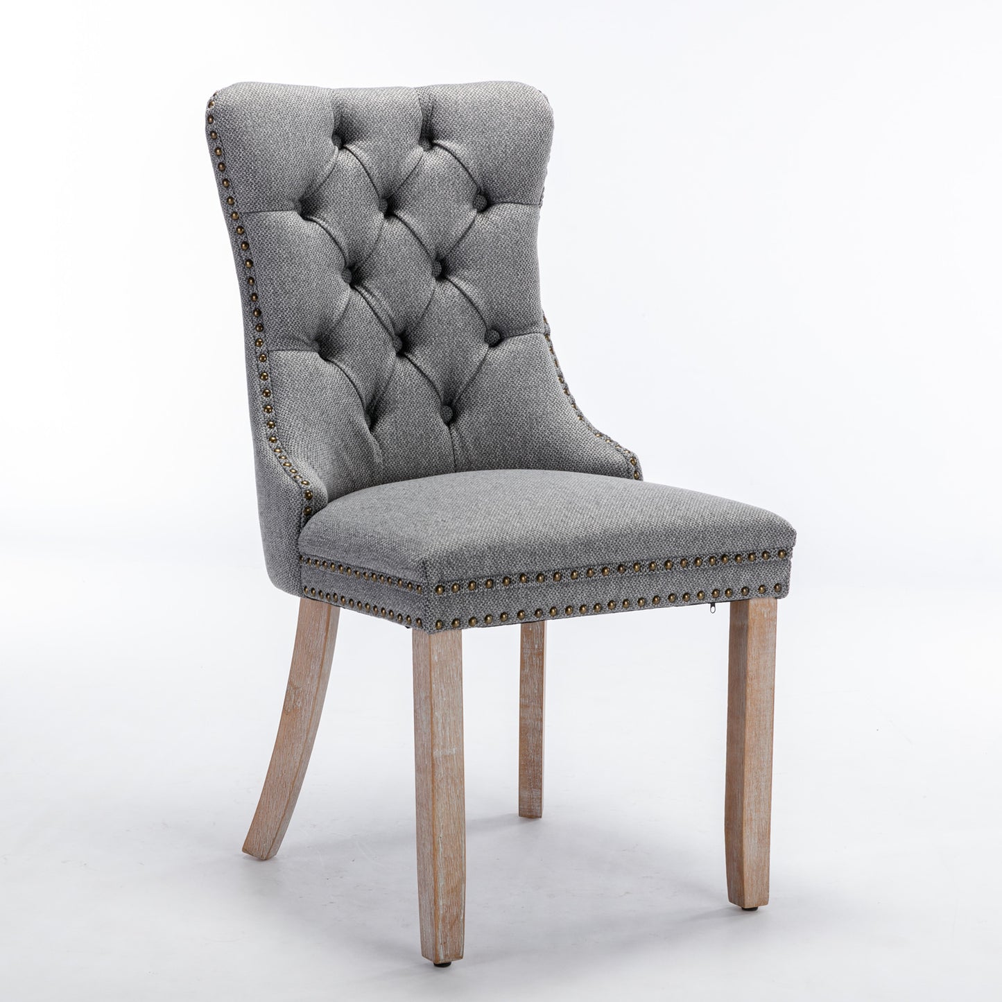 Grey tufted upholstered dining chair with brass nailhead trim and wooden legs