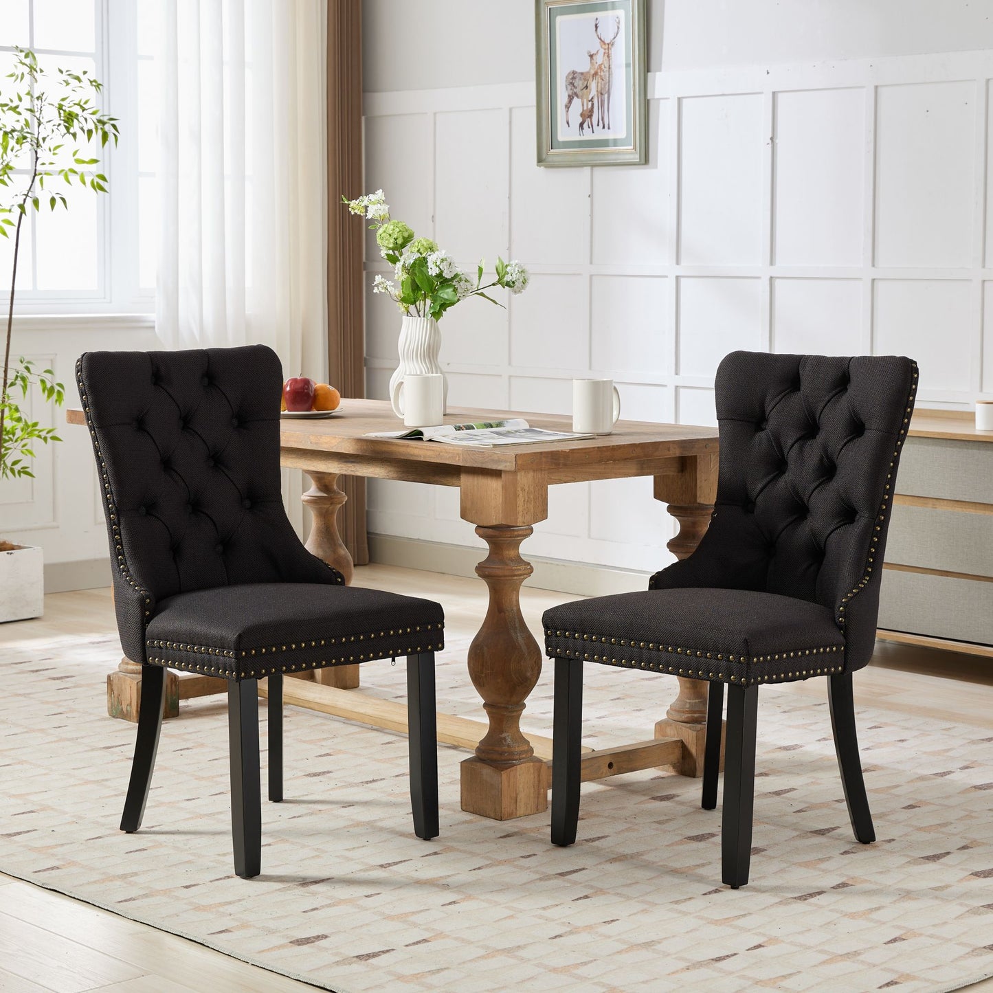 Black upholstered dining chair with button tufting and brass nailhead trim