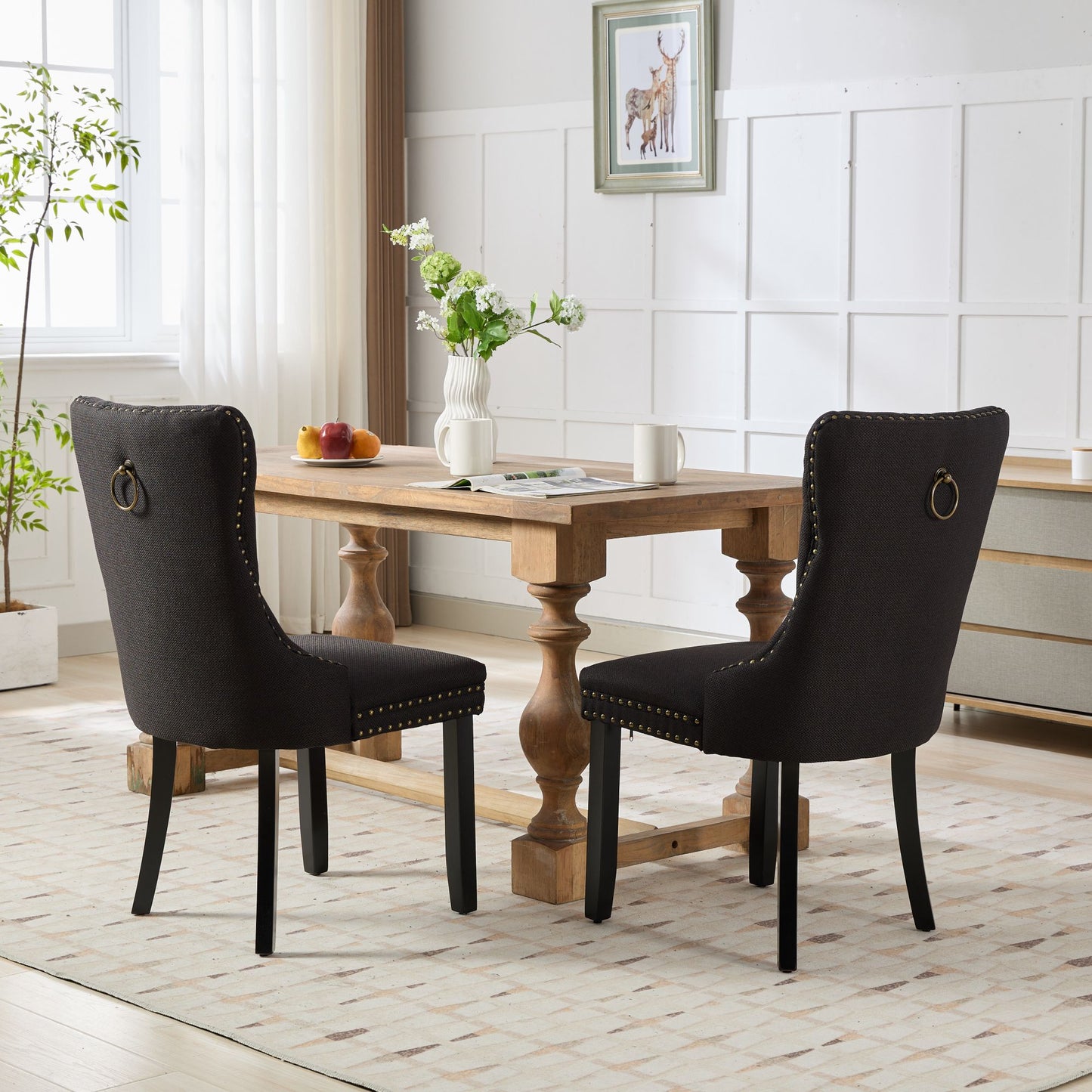 Dark grey upholstered dining chair with brass studs and ring pull