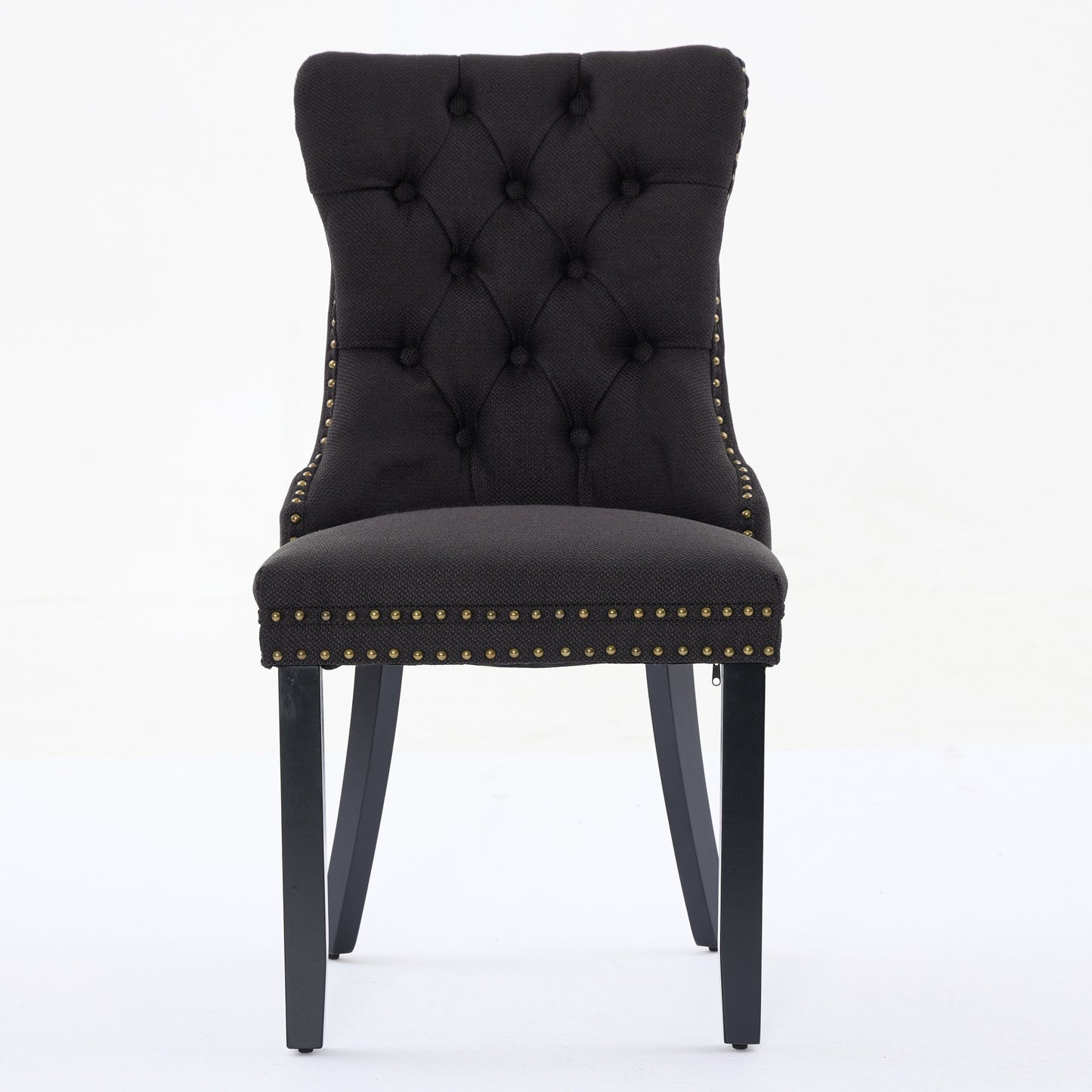 Black upholstered dining chair with diamond tufting and brass nailhead trim