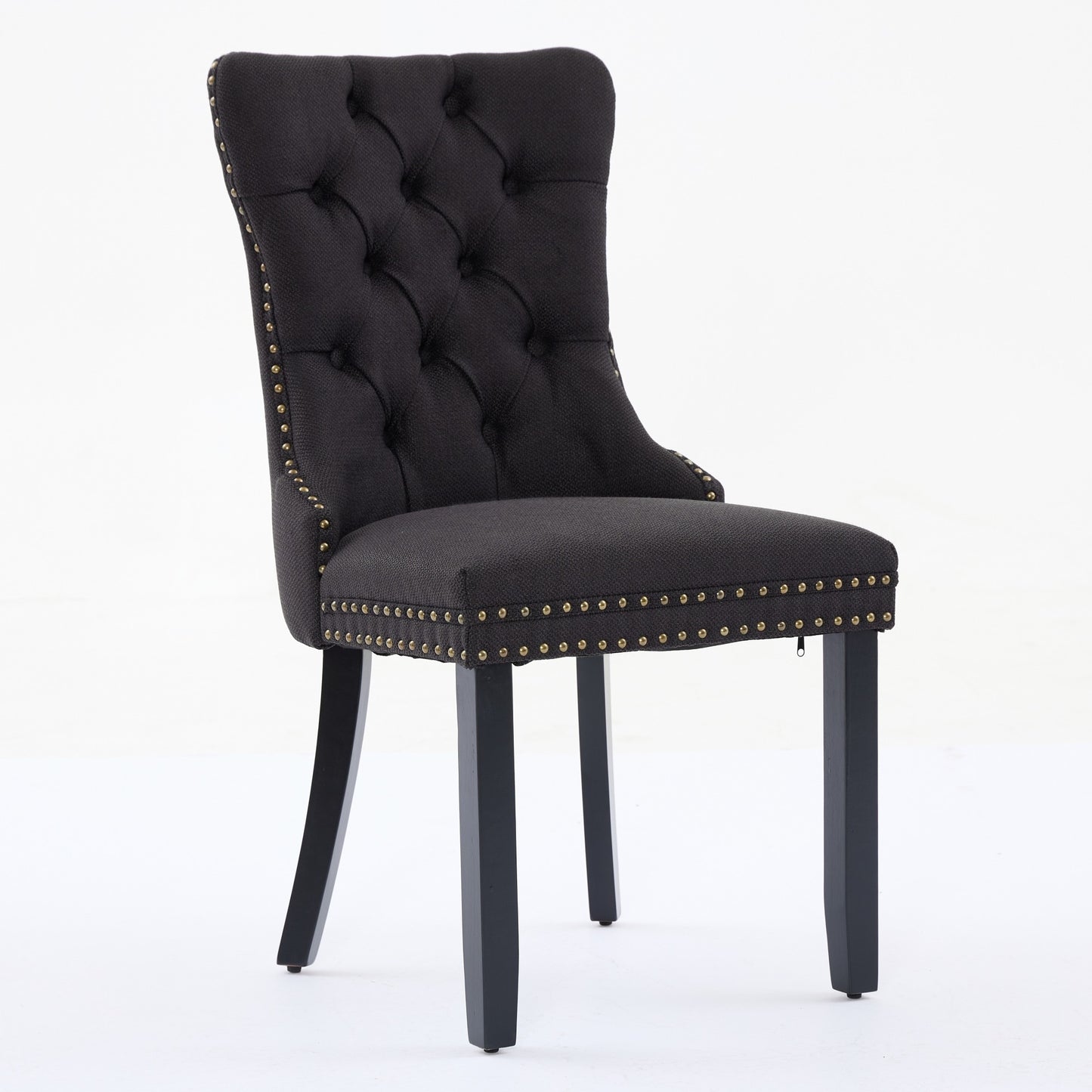 Black tufted dining chair with gold nailhead trim