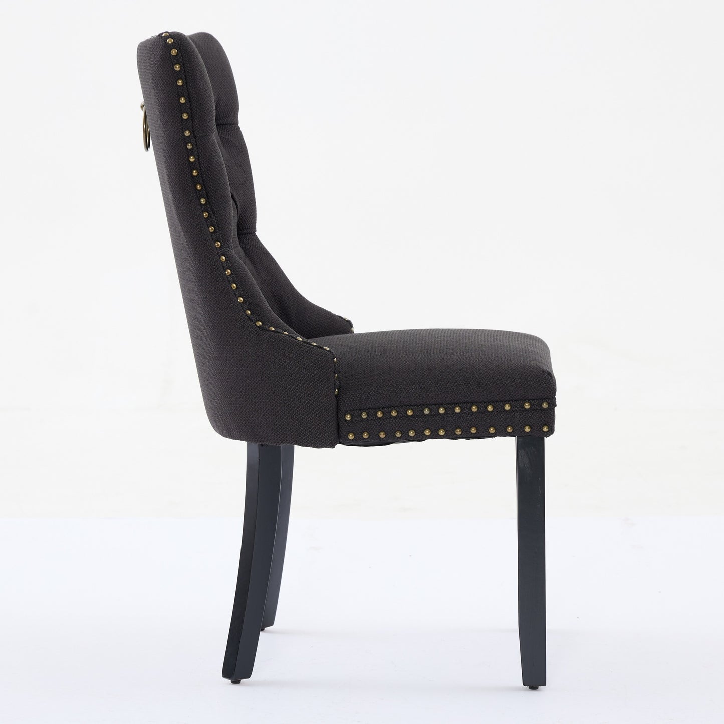 Dark grey tufted accent chair with brass nailhead trim and ring pull