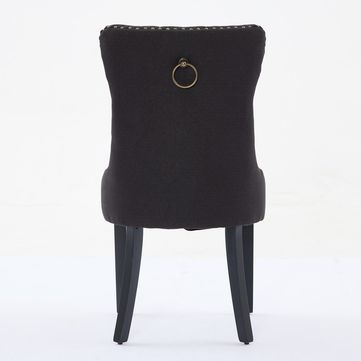 Dark gray upholstered dining chair with brass ring pull and nailhead trim