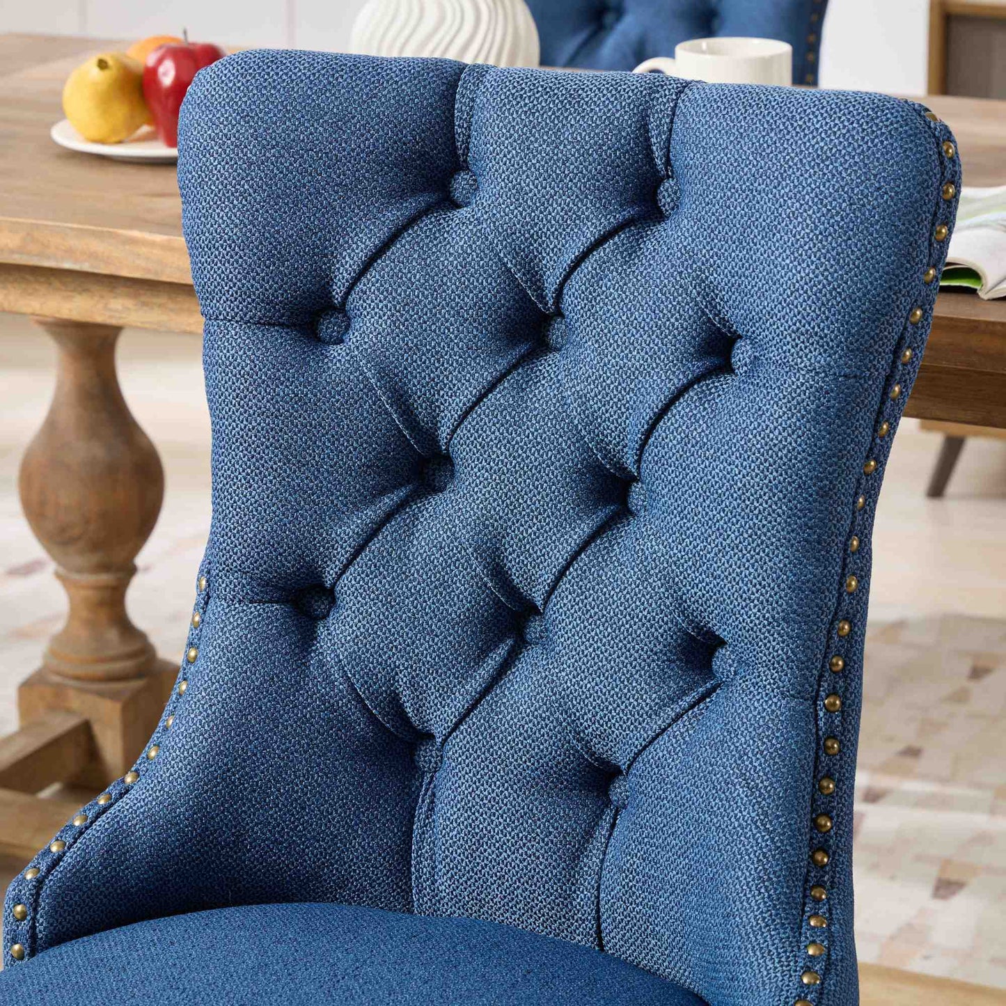 Blue tufted upholstered dining chair with brass nailhead trim