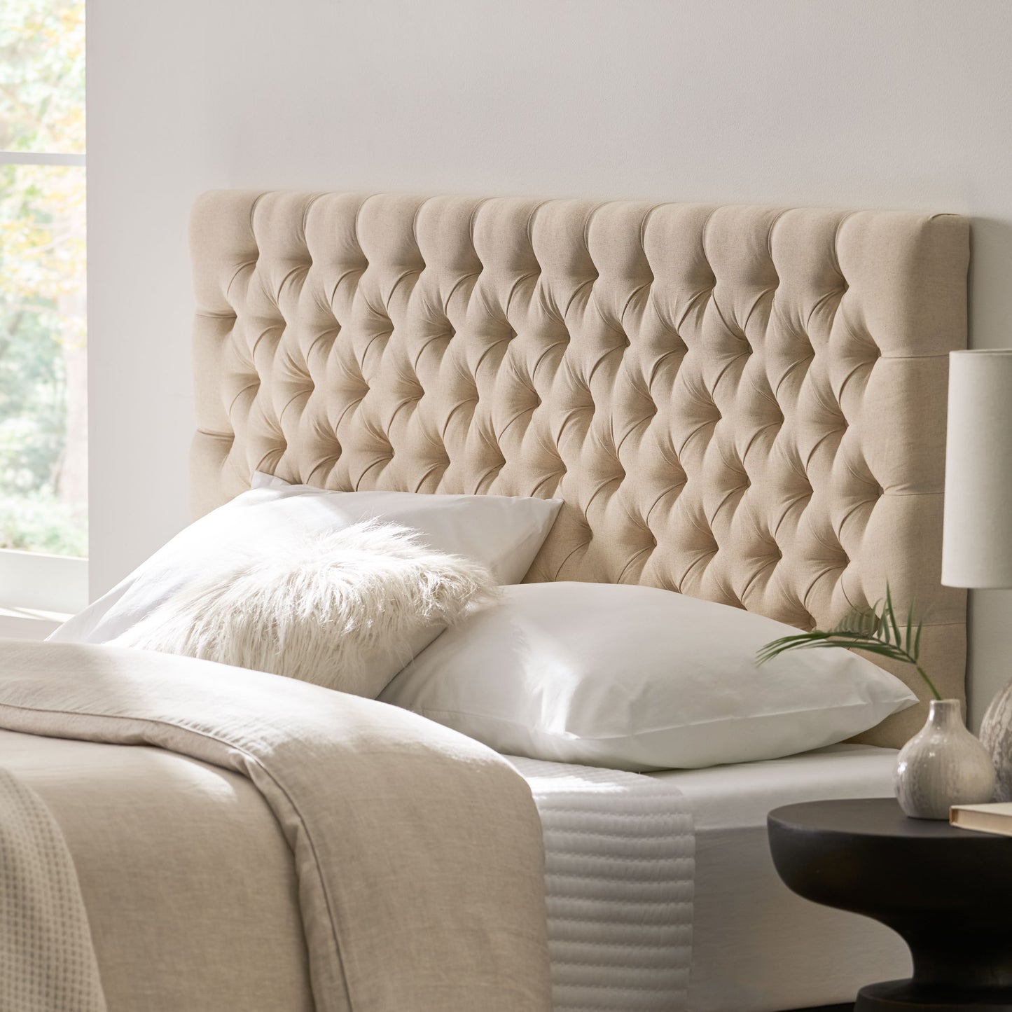 Tufted beige fabric headboard with diamond button tufting