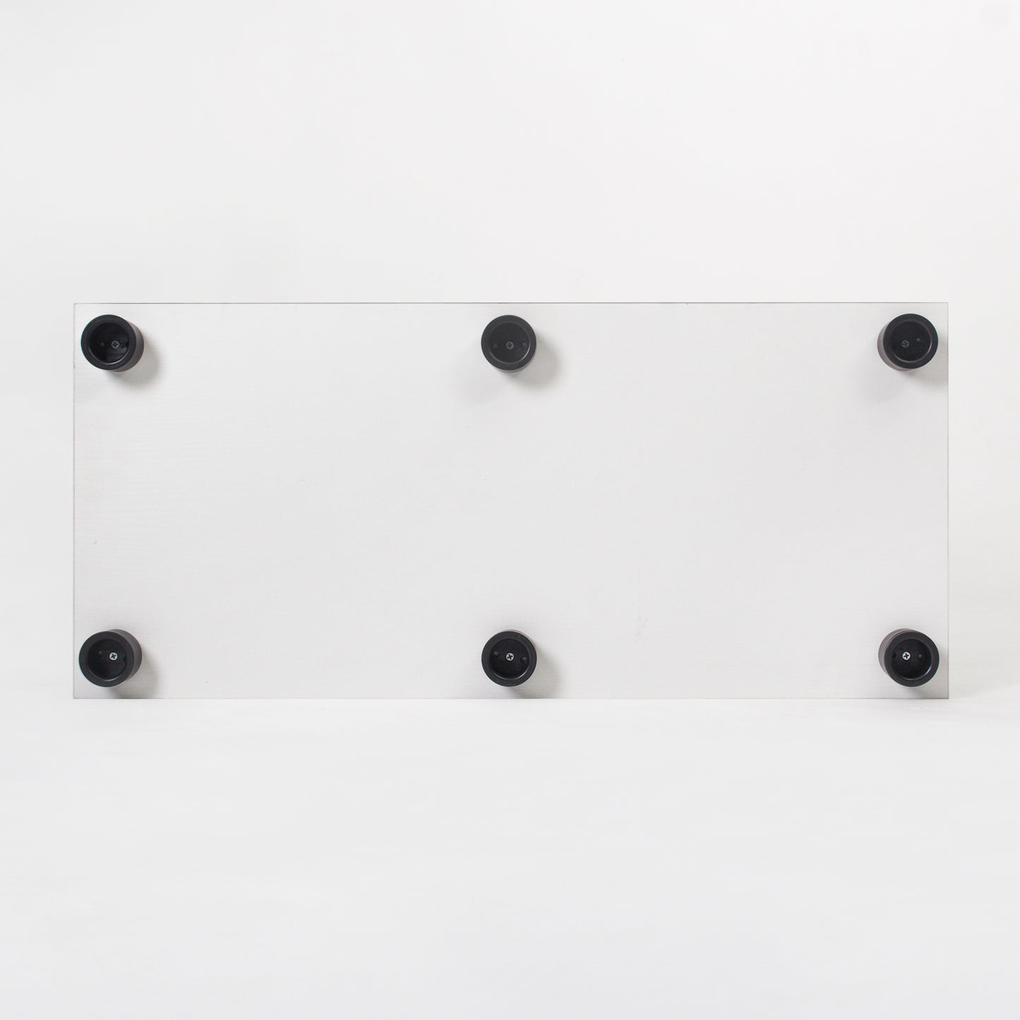 White rectangular shelf with six black rubber feet for stability