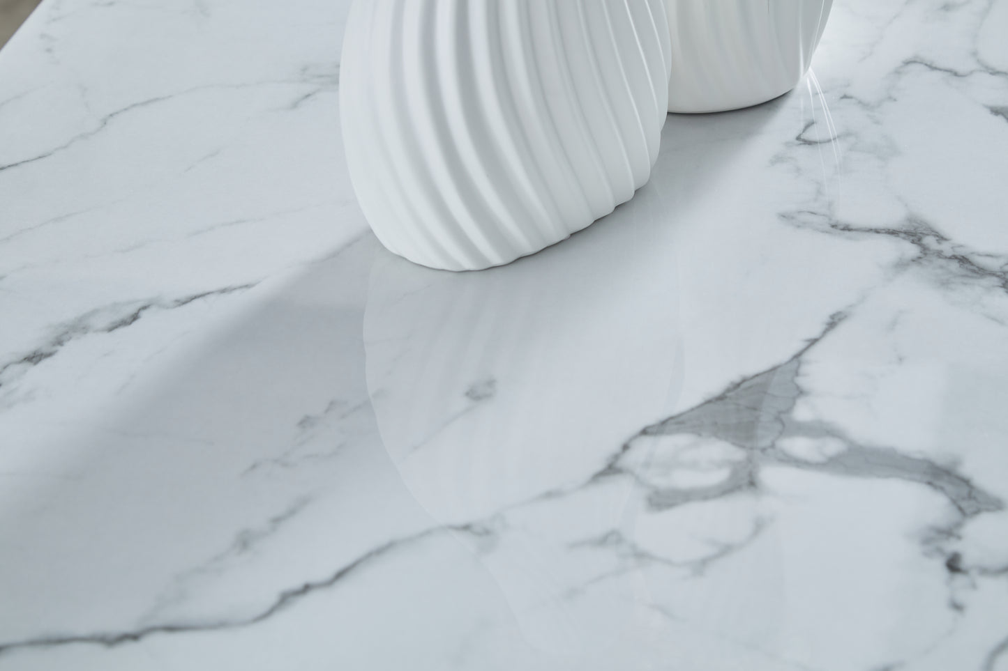 White ceramic vase with swirling texture on faux marble surface
