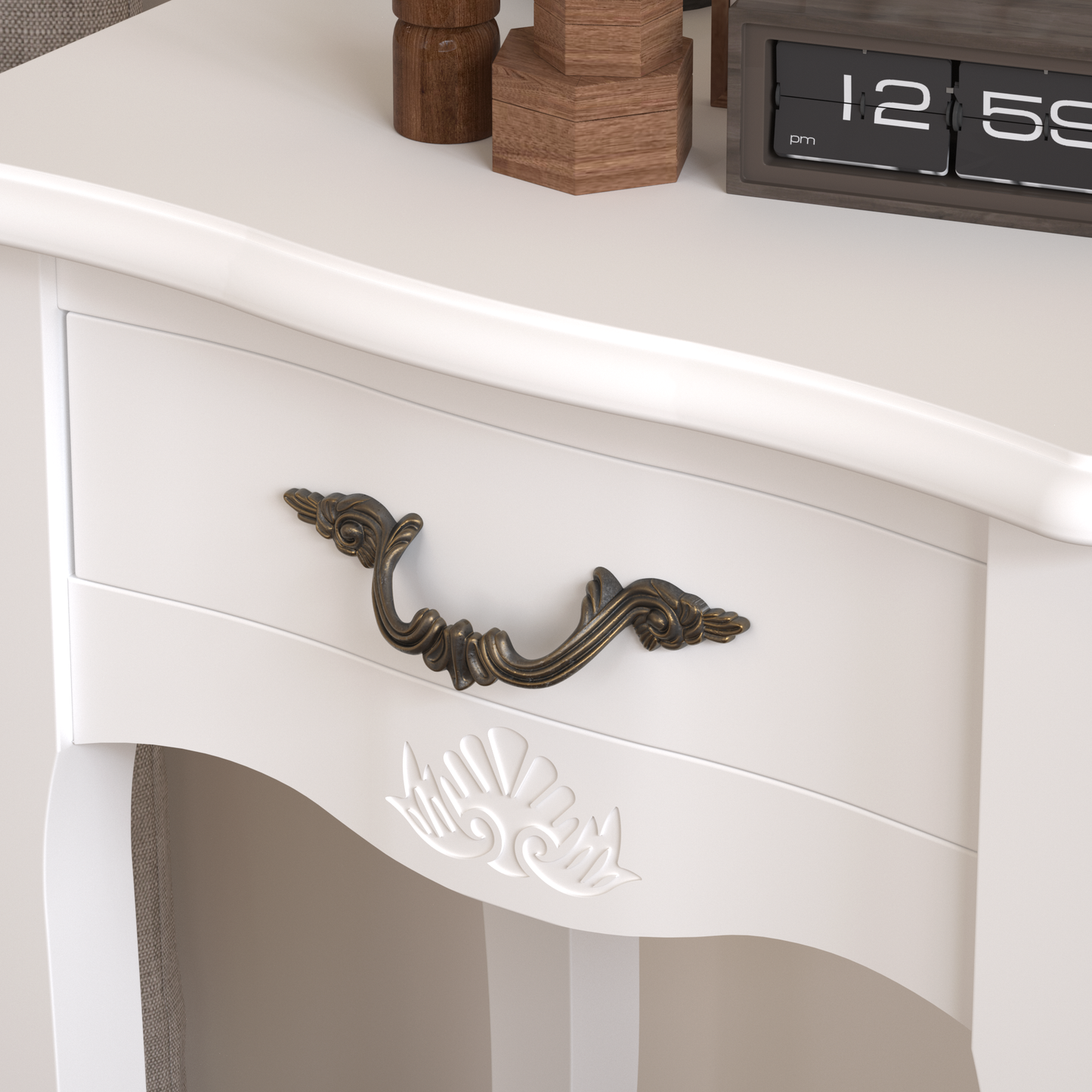 White vintagestyle drawer pull with ornate detailing on a cream dresser