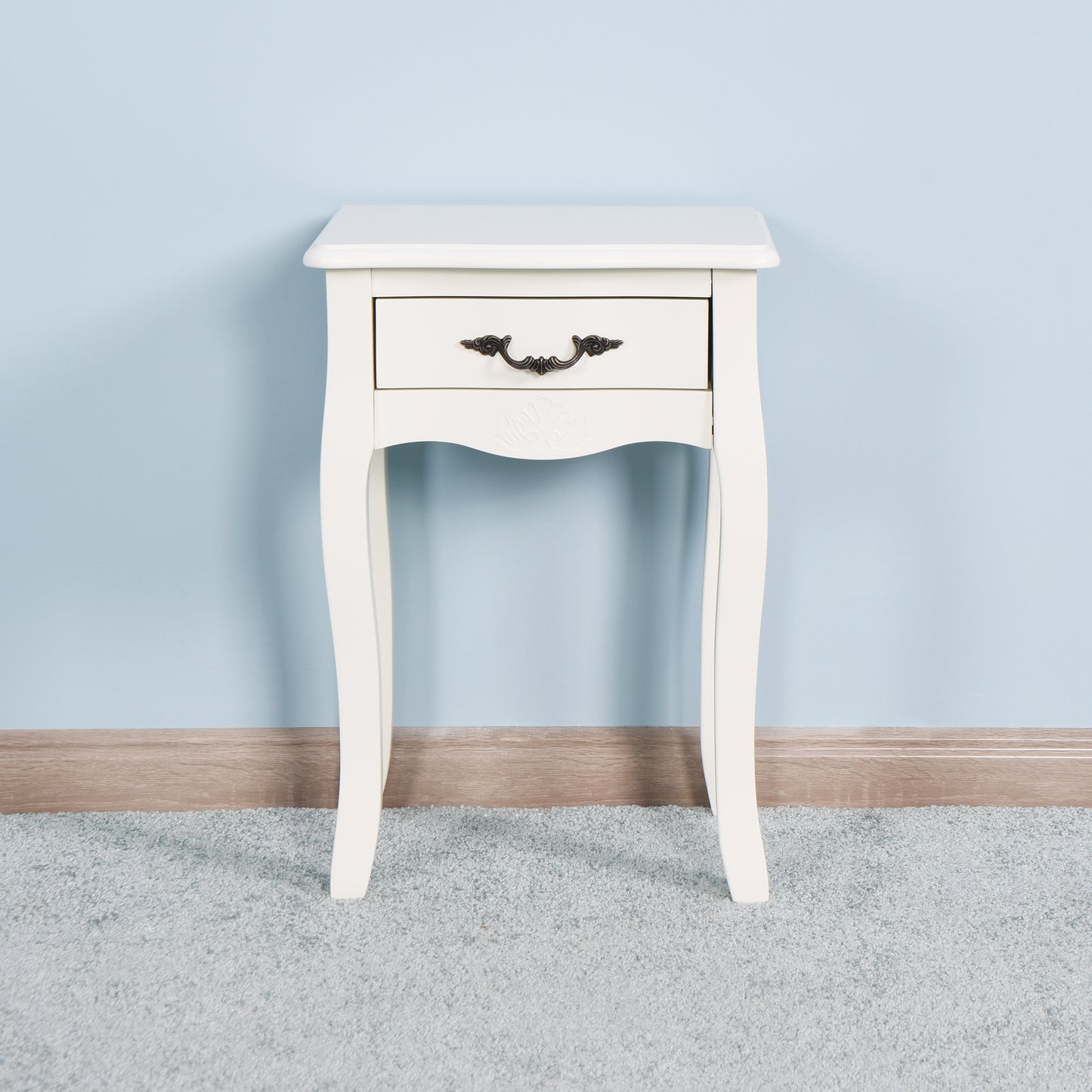 White vintage nightstand with carved detailing and a bronze drawer pull