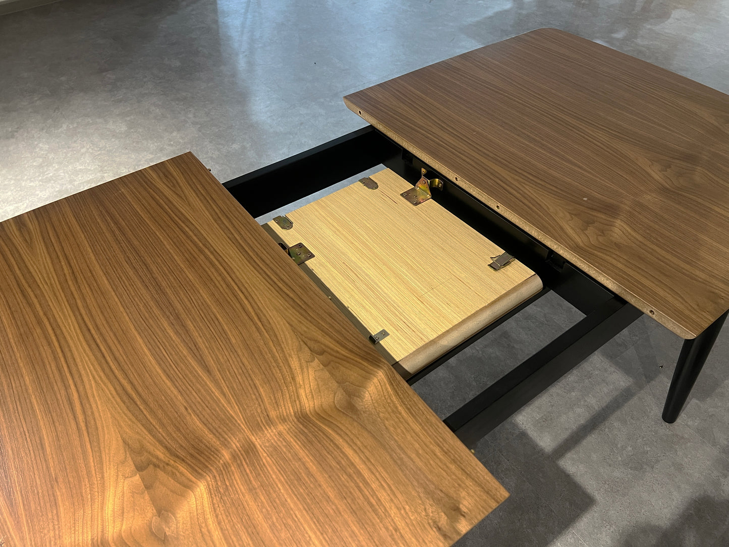 Walnut dining table with extending leaf mechanism shown
