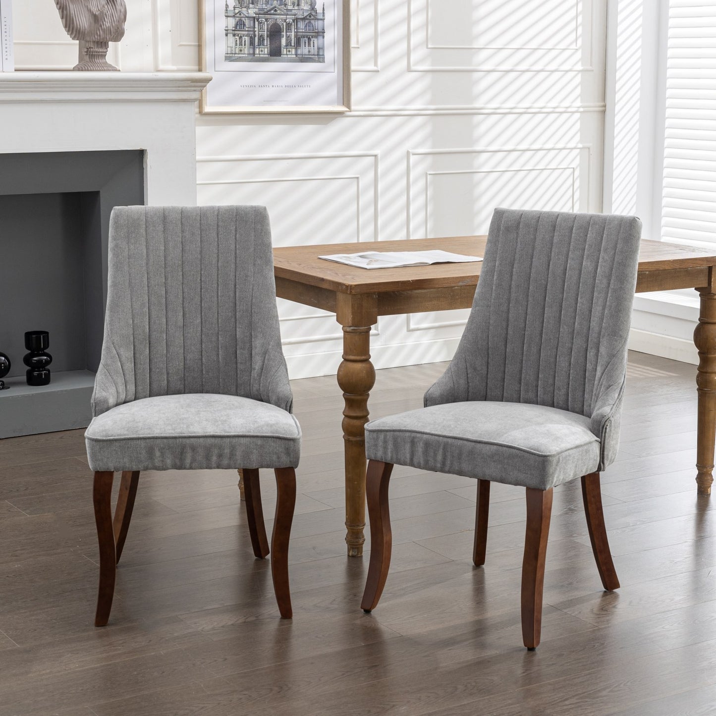 Pair of grey upholstered dining chairs with channel tufting and dark wood legs