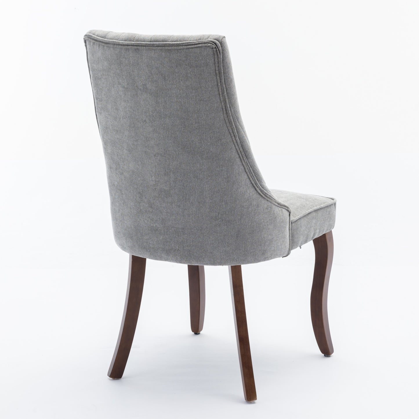 Grey upholstered dining chair with tufted back and dark wood legs