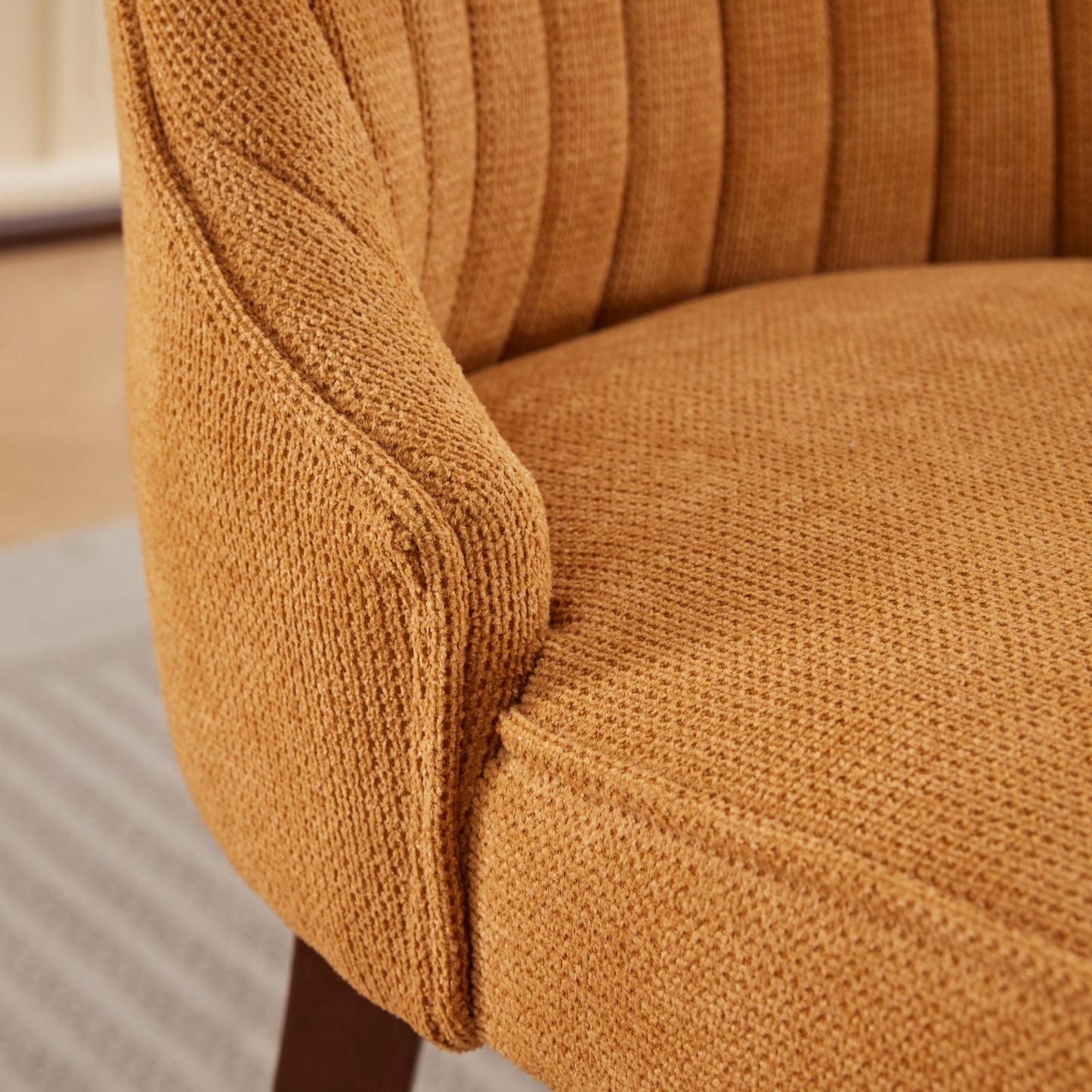 Textured orange accent chair armrest