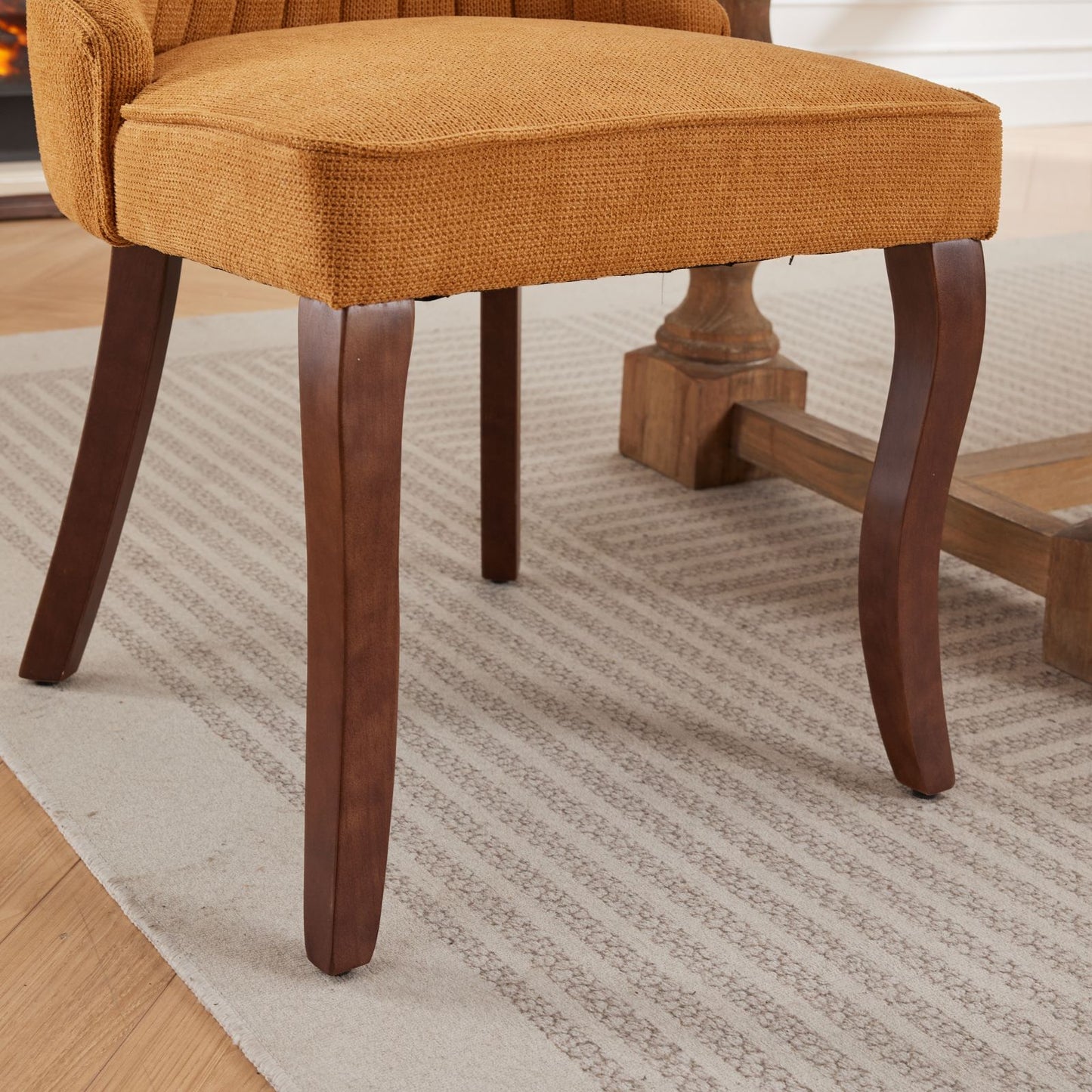 Orange upholstered dining chair with carved dark wood legs