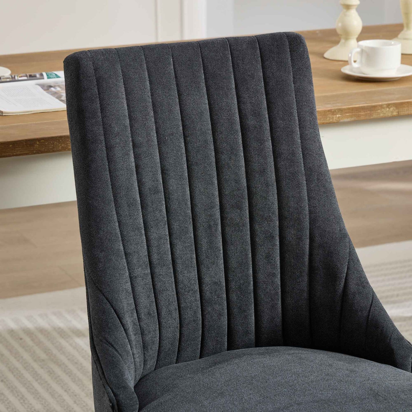 Dark gray fabric dining chair with vertical channel tufting on the backrest