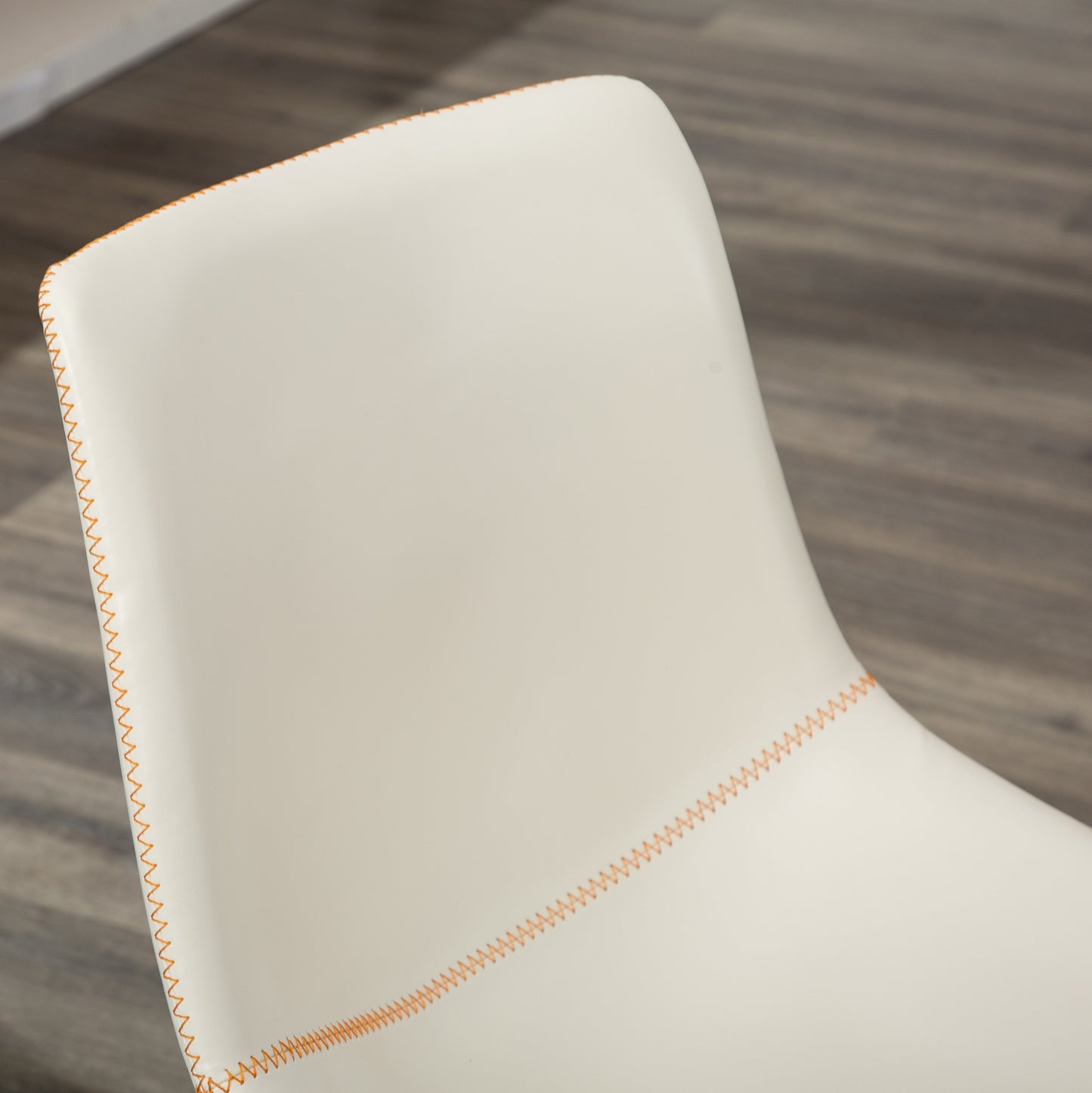 Cream faux leather accent chair with contrasting orange stitching