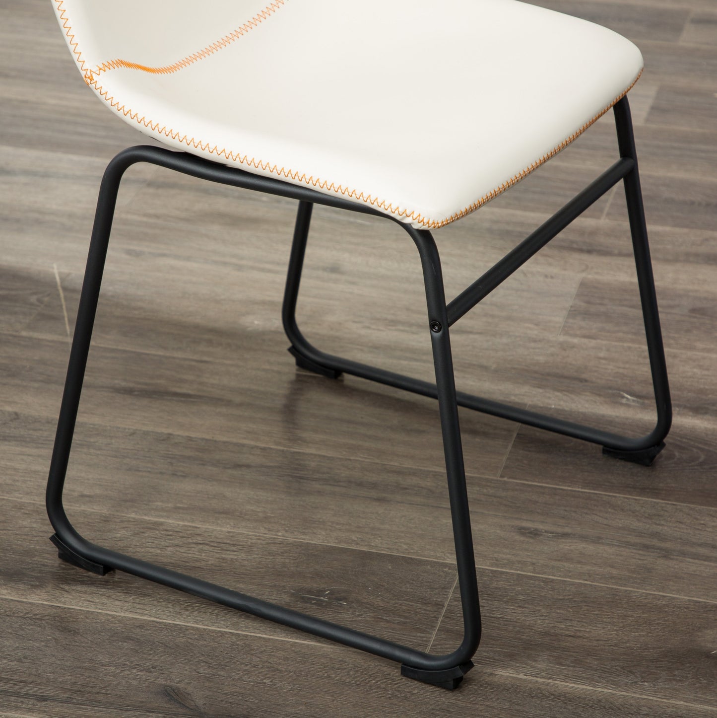 White faux leather dining chair with orange contrast stitching and black metal legs