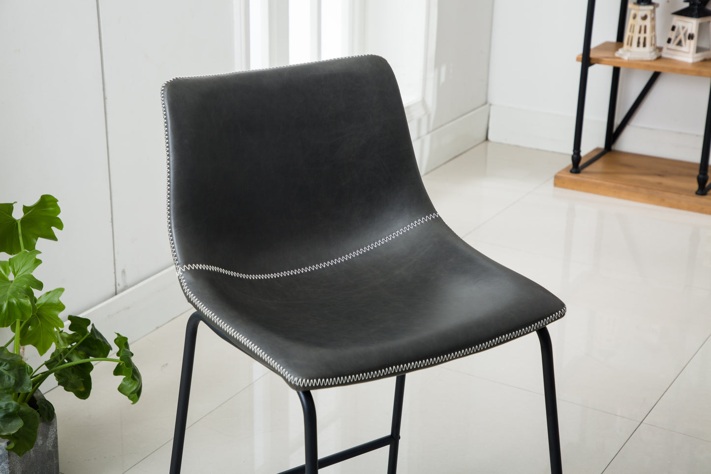 Black faux leather counter stool with white stitching