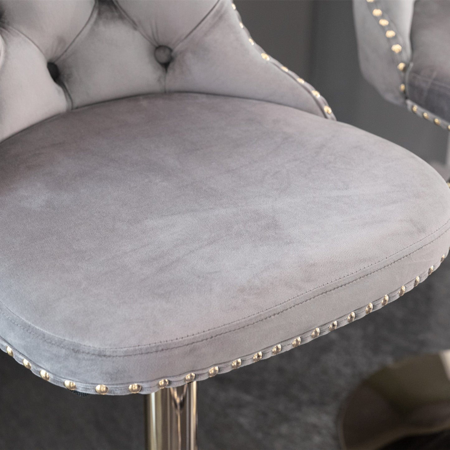 Grey velvet bar stool with gold stud accents and tufted back detail