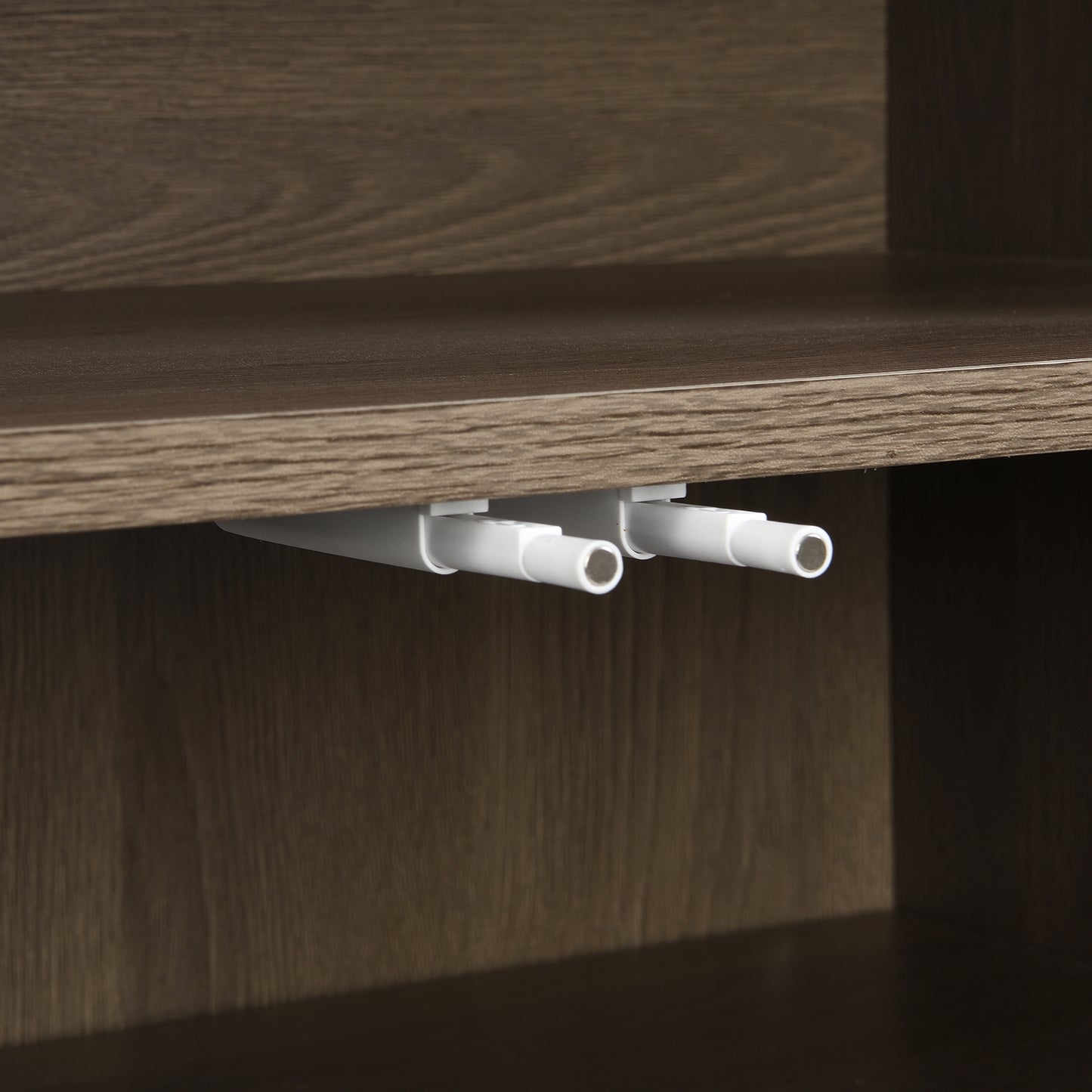 Closeup of two white pushtoopen latches installed on a dark wood shelf edge