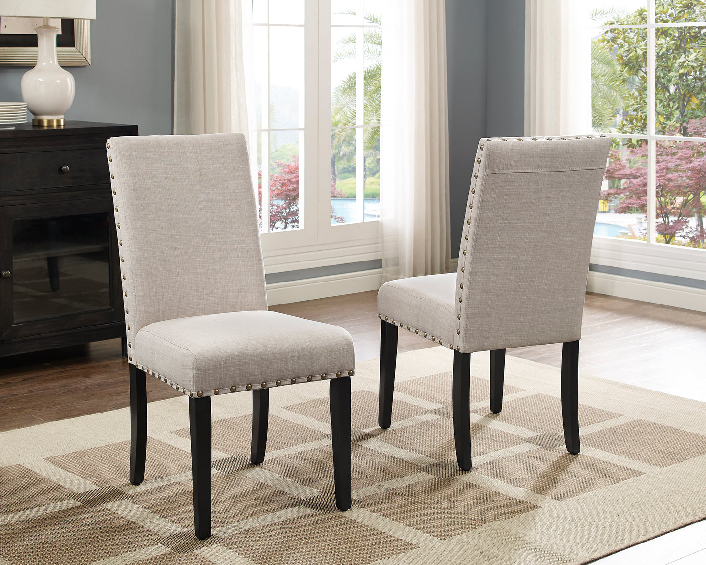 Light gray linen dining chair with nailhead trim and dark legs