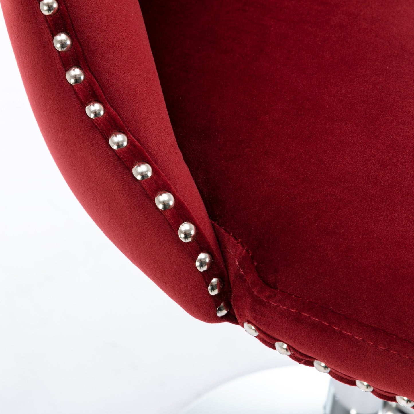 Red velvet accent chair armrest with silver nailhead trim