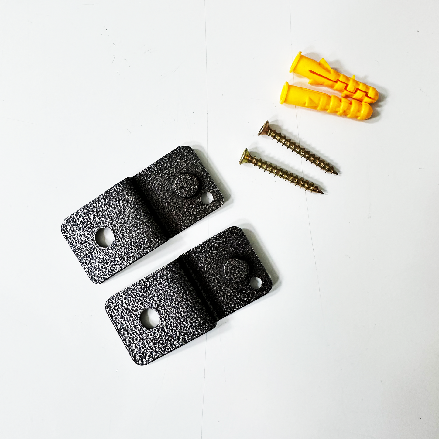 Textured black metal shelf brackets with screws and yellow wall anchors