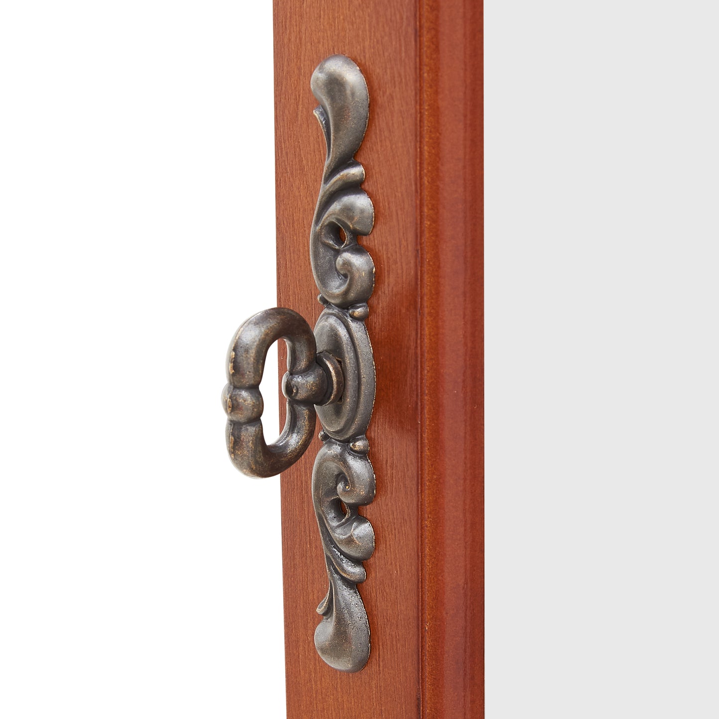 Antique brass ornate pull handle on wooden drawer