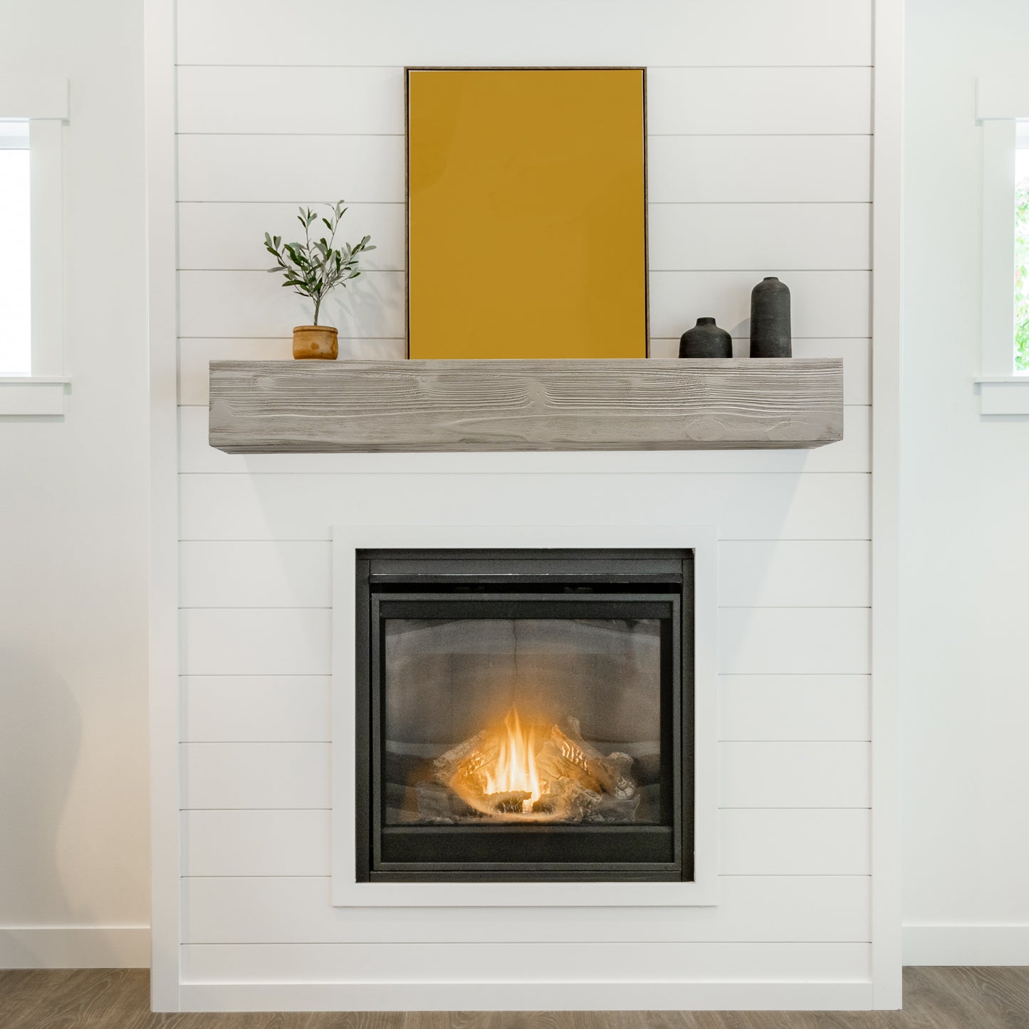 Modern gas fireplace with clean white shiplap surround and rustic wood mantel