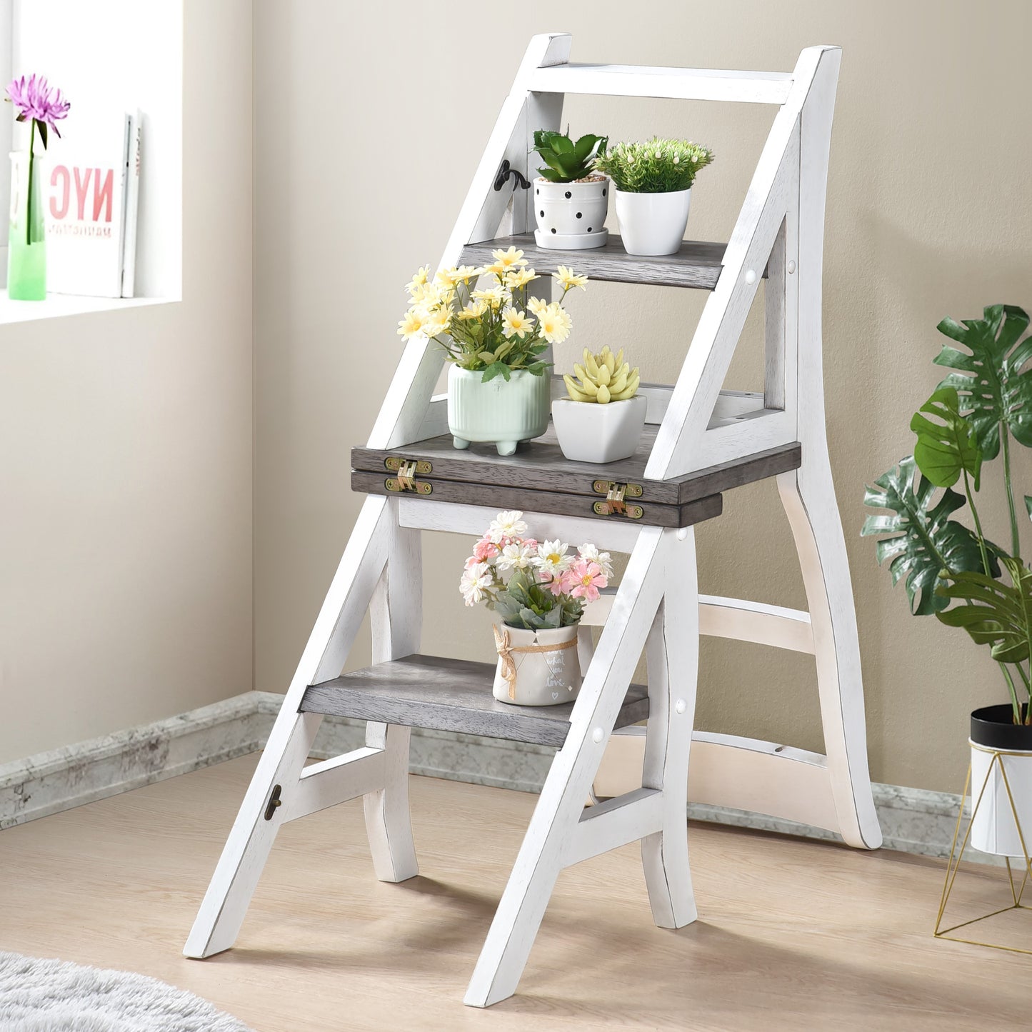White wooden step stool with three shelves adorned with potted plants and decorative flowers