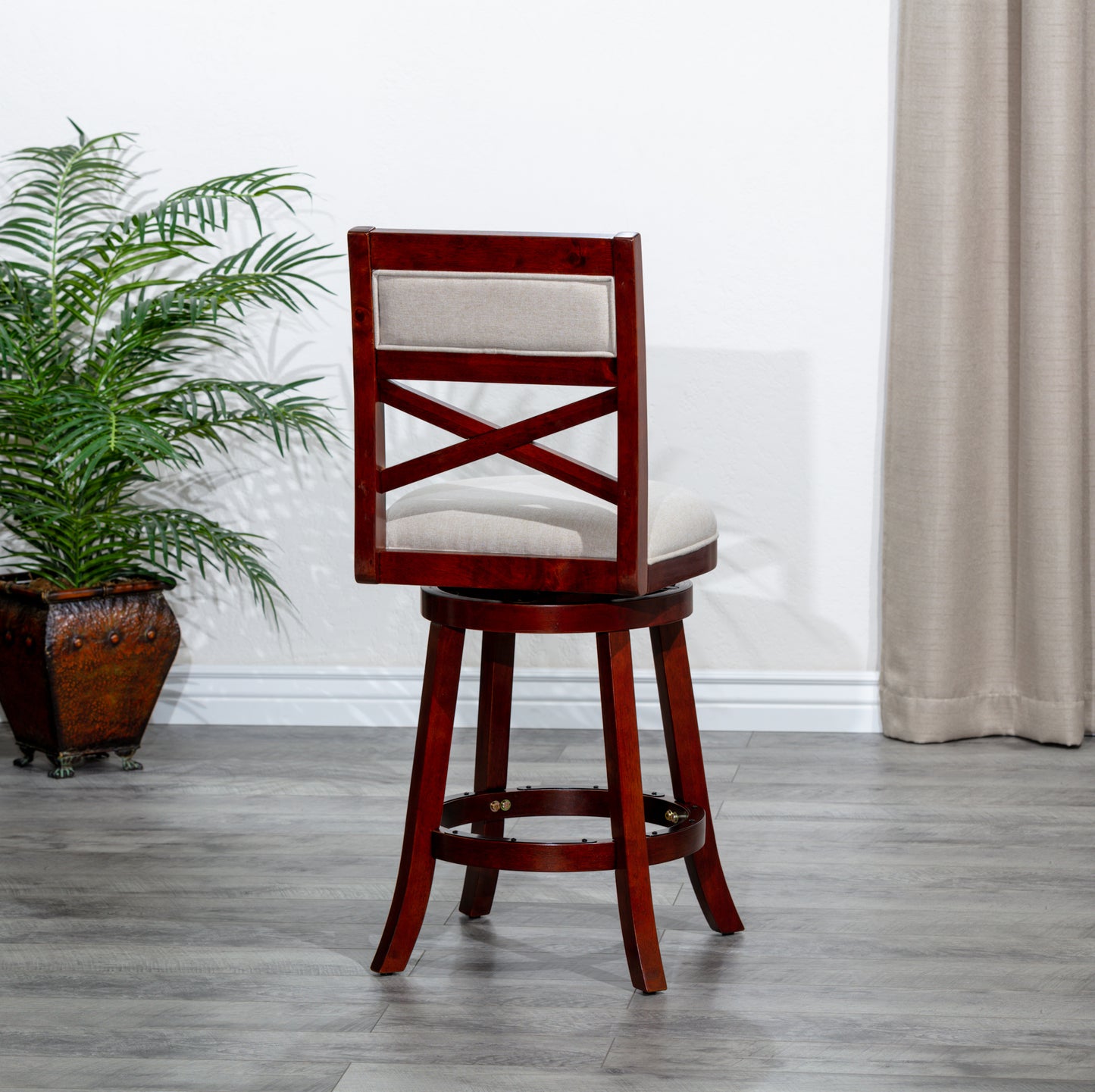 Swivel bar stool with dark cherry finish wood and upholstered beige seat