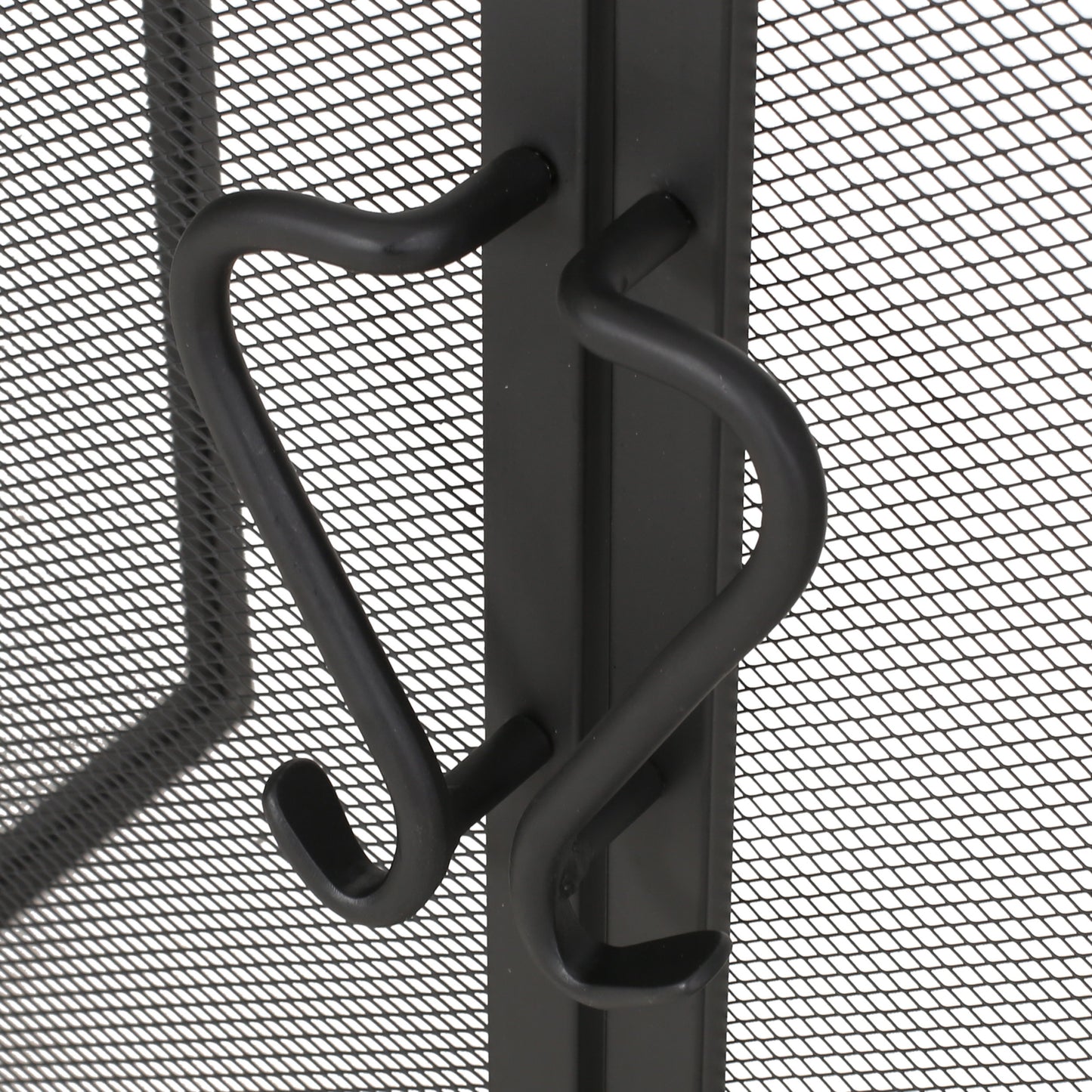 Black metal fireplace screen with decorative curved handles