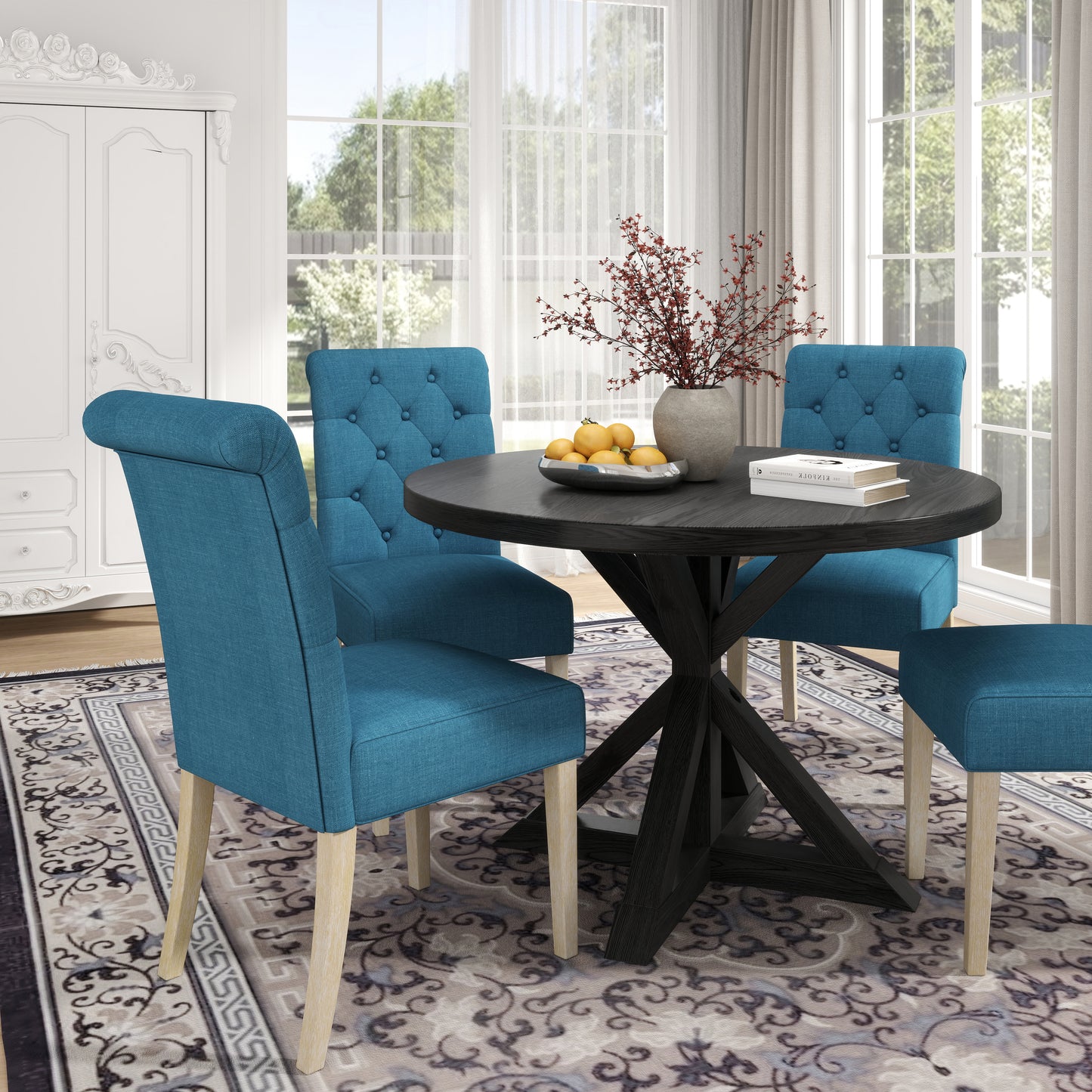 Round dark wood dining table with four teal upholstered chairs
