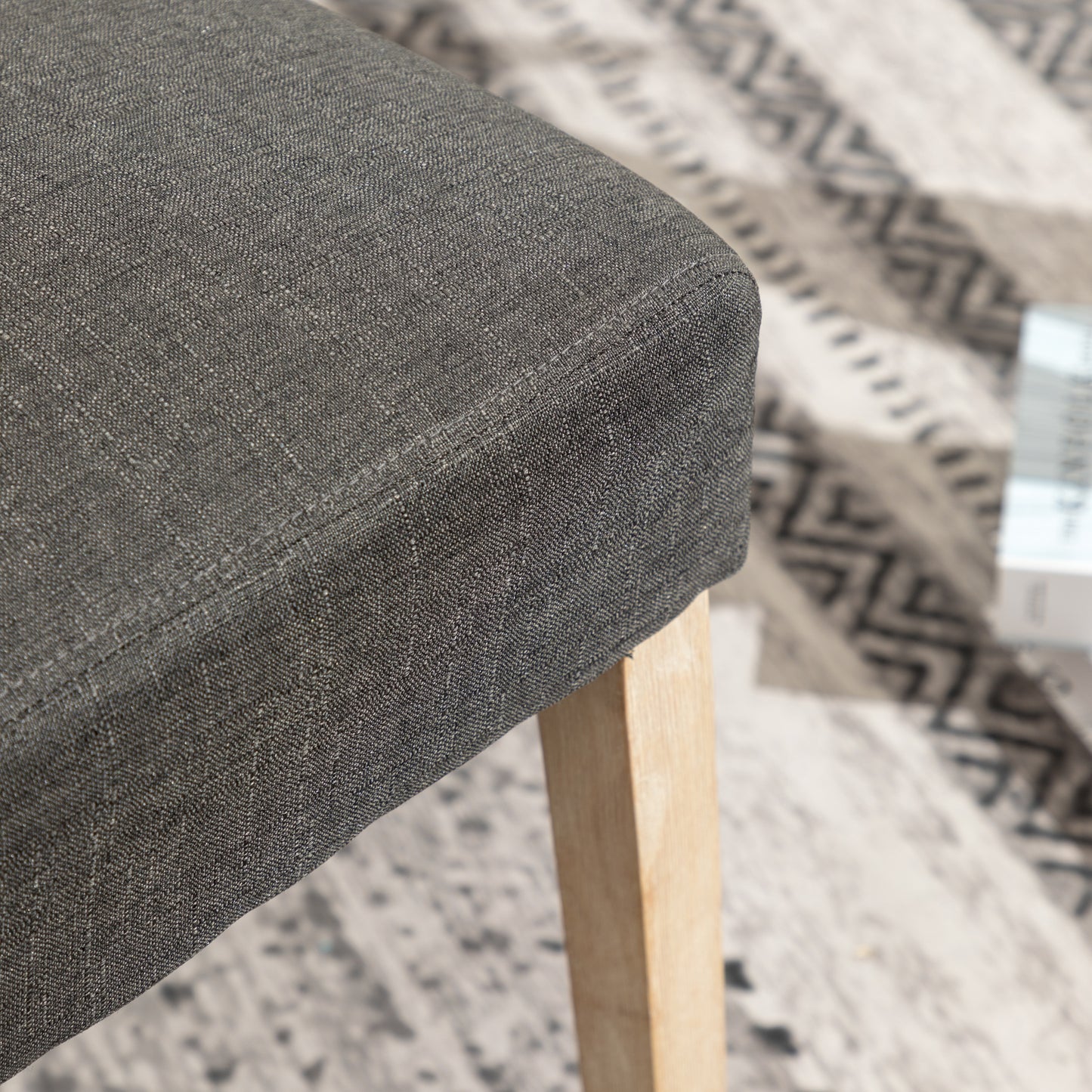 Closeup of charcoal gray woven fabric on a modern accent chair