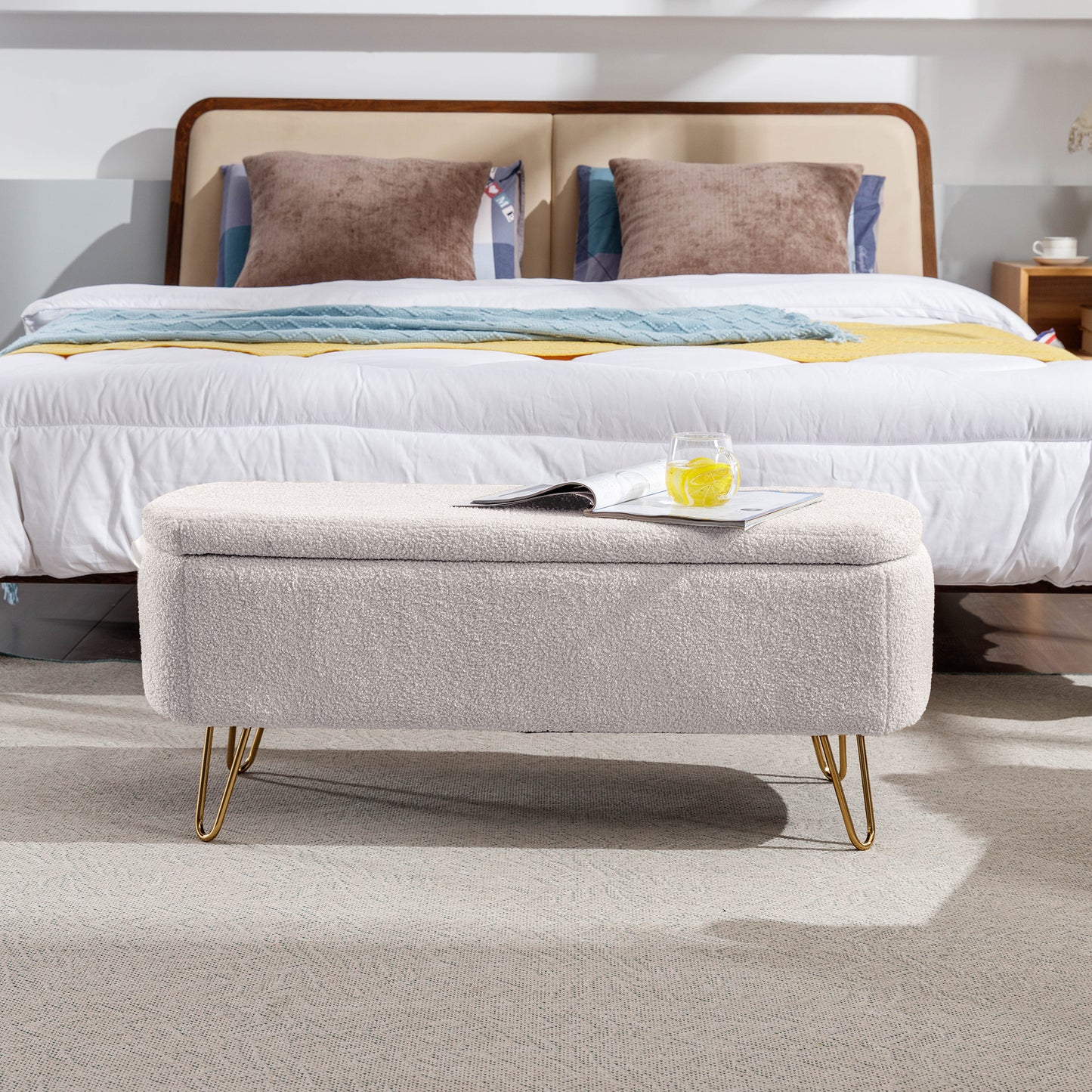 Cream boucle storage ottoman with gold hairpin legs and open lid revealing storage space