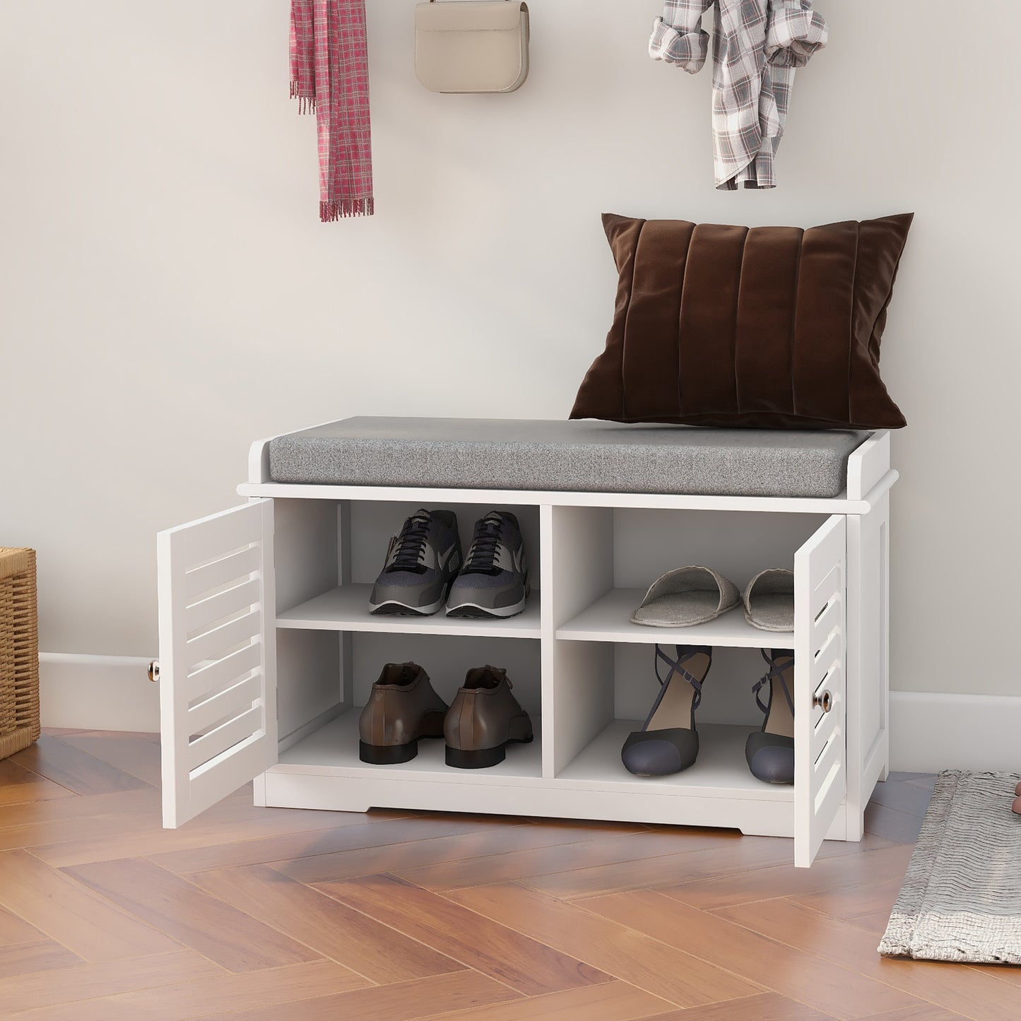 White entryway shoe bench with cushioned seat holding various footwear and accessories