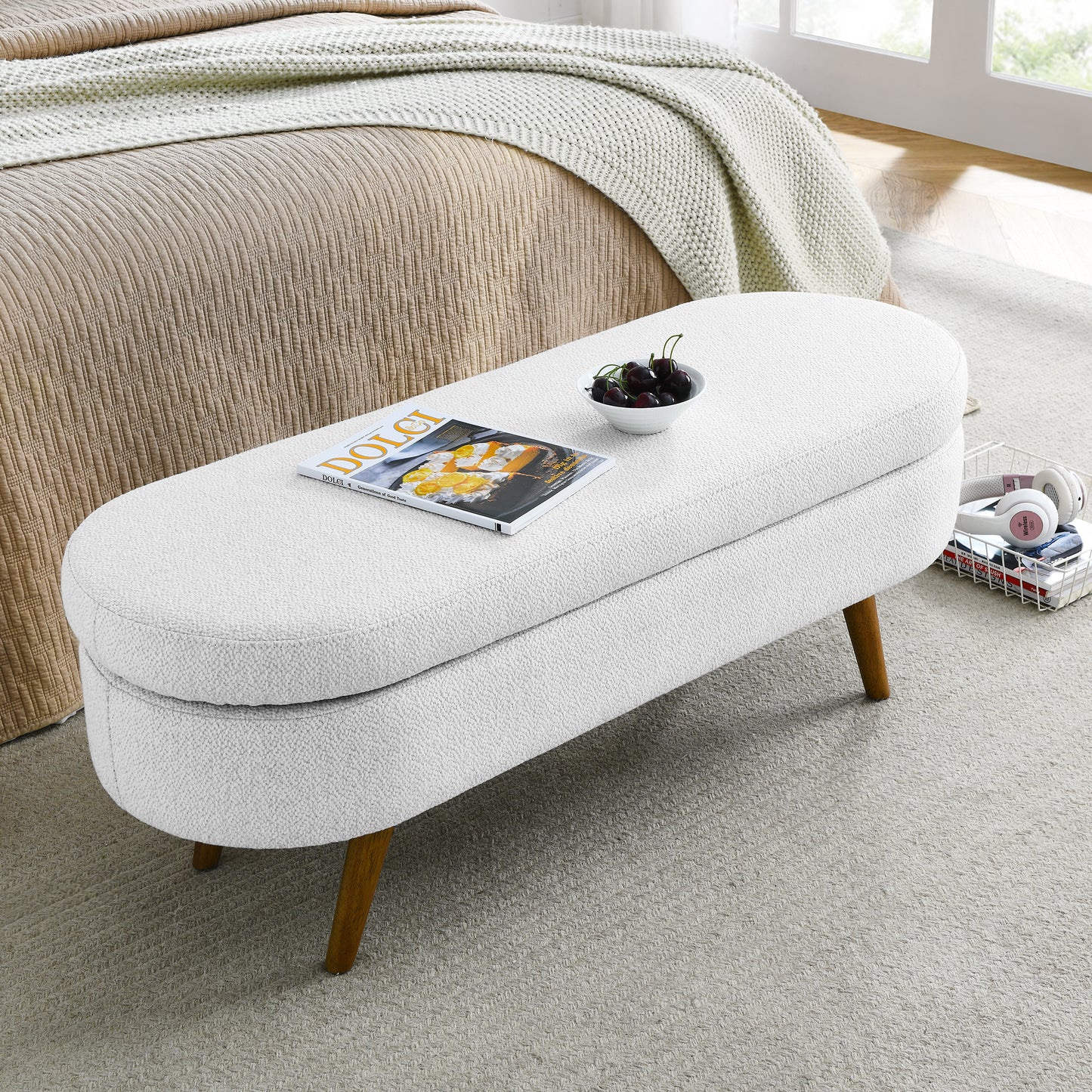 White boucle storage bench with wooden legs and a magazine