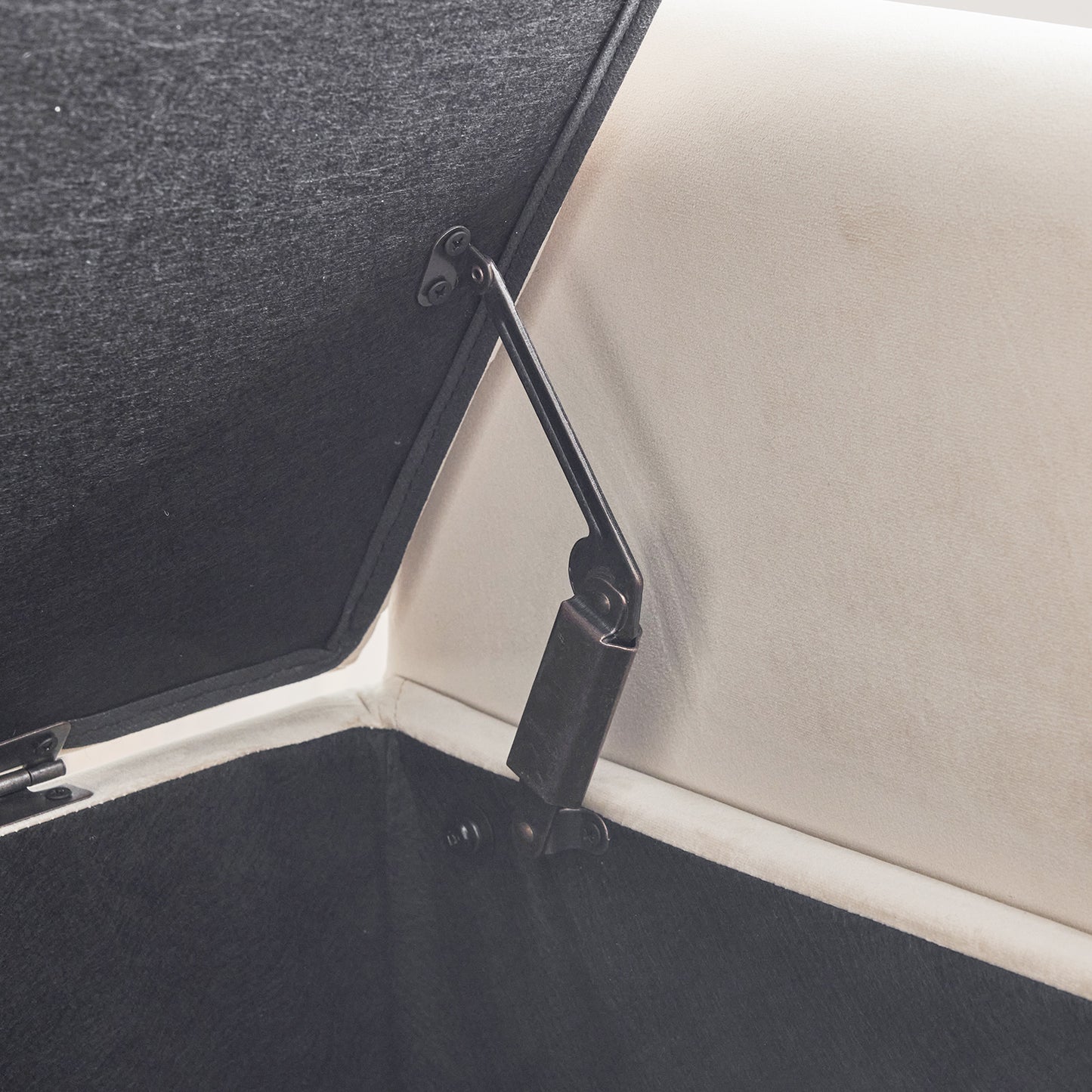 Black velvet upholstered ottoman interior with hydraulic lift mechanism visible