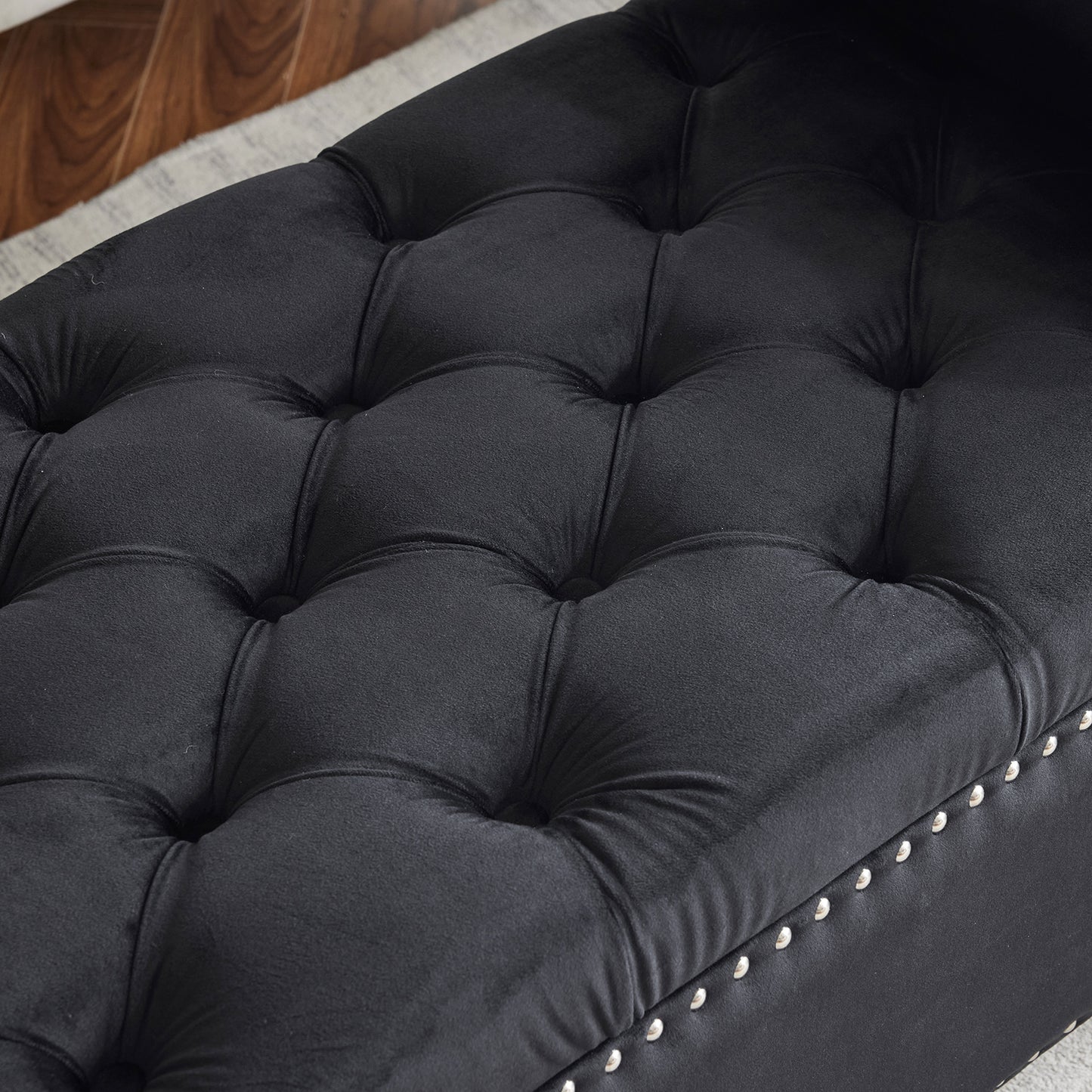 Black velvet storage ottoman with tufted top and silver nailhead trim