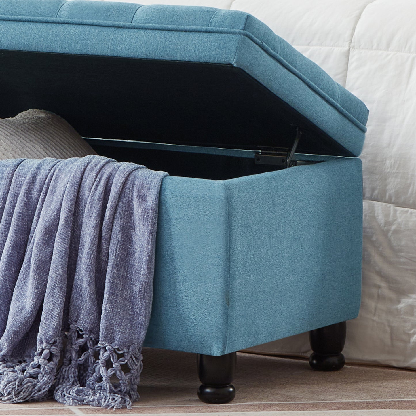 Blue fabric storage ottoman with tufted lid