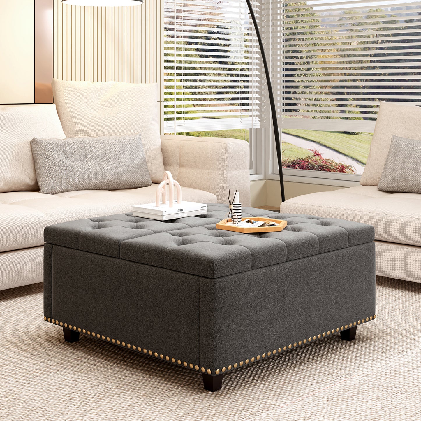 Dark gray tufted storage ottoman with gold nailhead trim